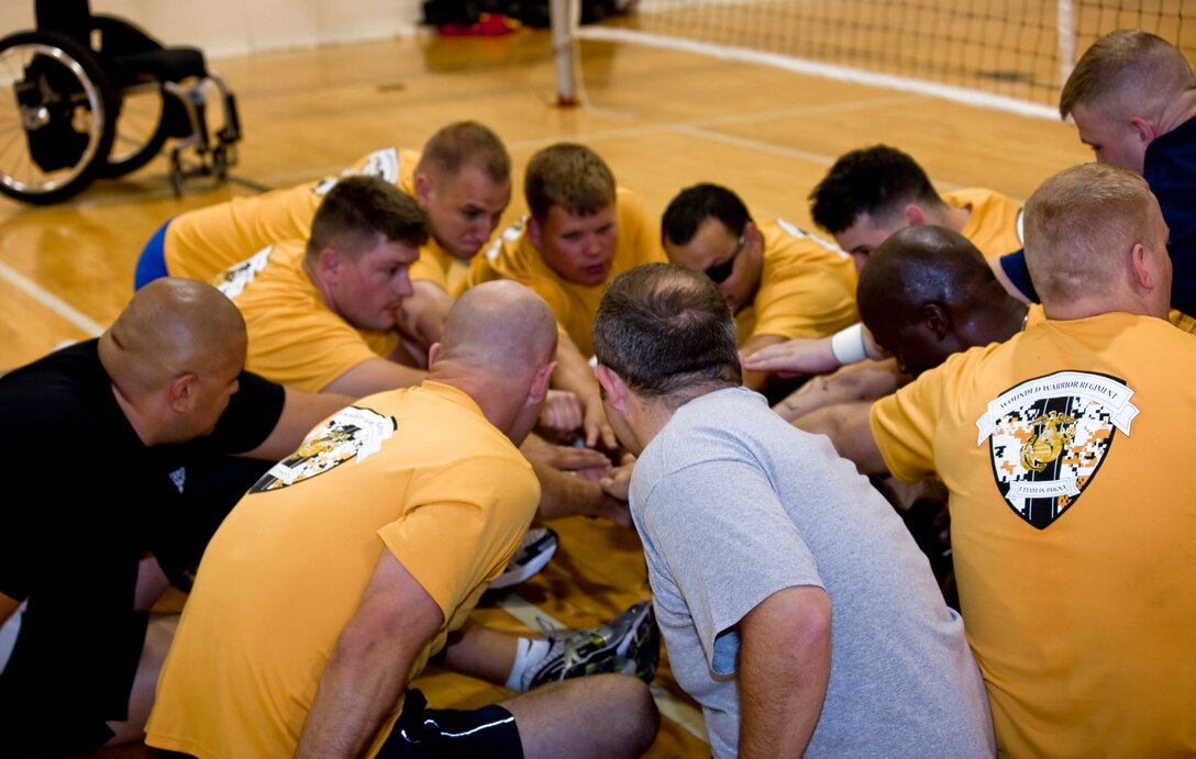 All-Marine Warrior Games Team Athletes and staff meet all-hands in at the beginning of a practice April 28, at the base gym. Sitting volleyball is one of the Warrior Games events and one of the only team sports in the competition. Sitting volleyball features five players per side and differs from volleyball by allowing players to block serves, maintaining ground contact at all times.