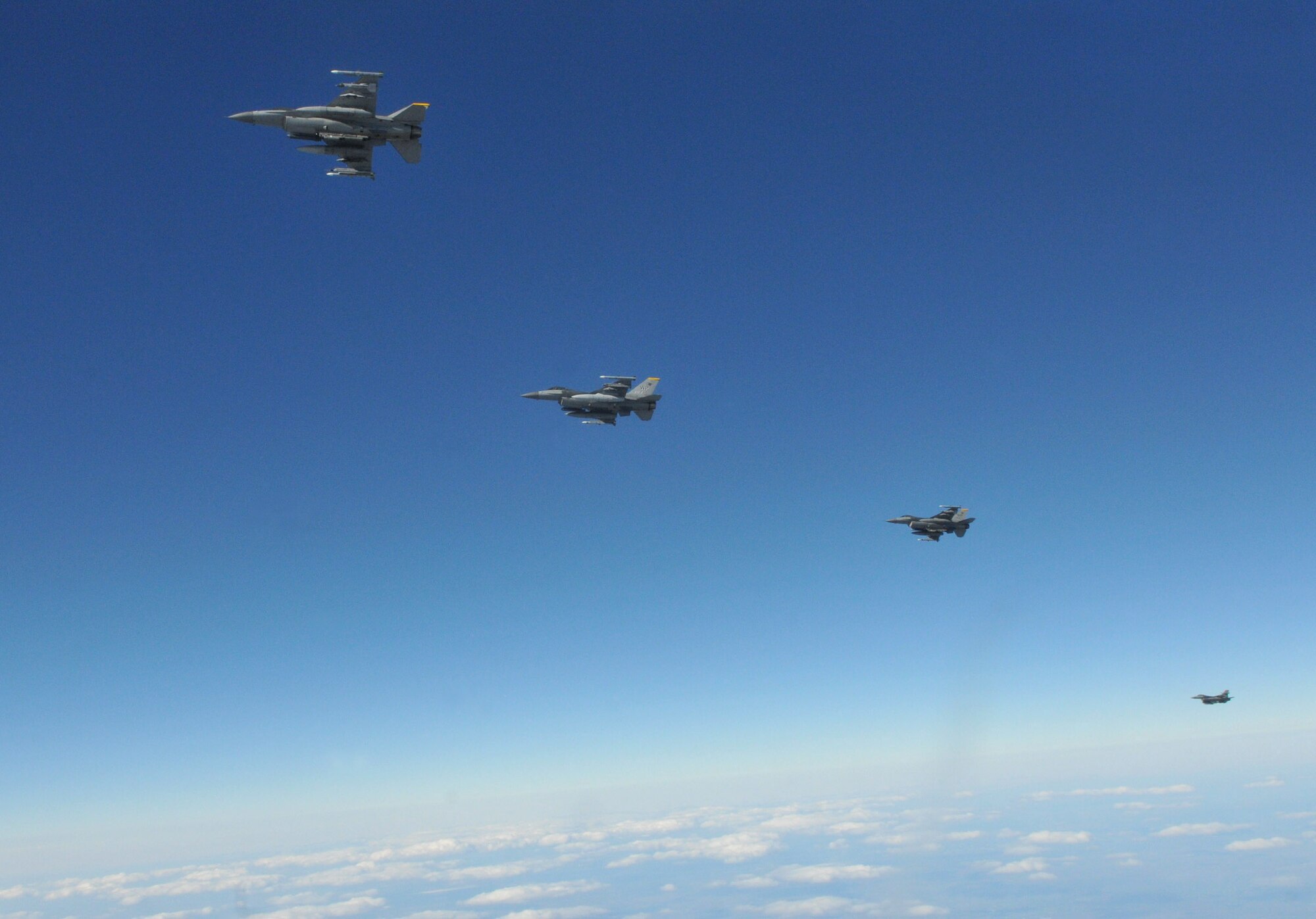 Four F-16 Fighting Falcons pilots with the 8th Fighter Wing's 80th Fighter Squadron, Kunsan Air Base, Republic of Korea, fly back into the simulated war after refueling from a KC-135 Stratotanker from McConnell Air Force Base, Kansas, during Red Flag-Alaska April 27. Red Flag-Alaska is a 10-day air combat training exercise that provides multi-service, multi-platform coordinated, combat operations in a simulated combat environment. (U.S. Air Force photo/Capt. Shannon Collins)