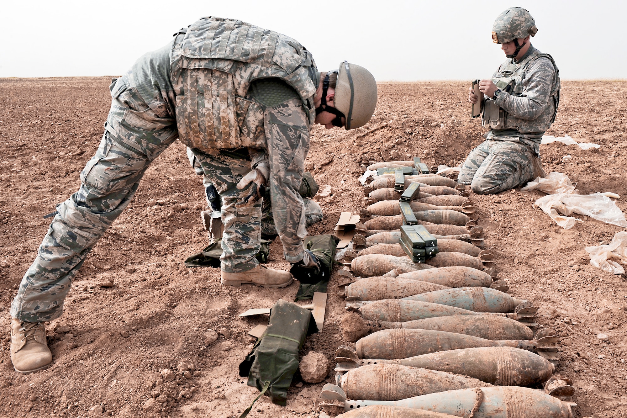 Staff Sgt. Matt Skelton (left) and Staff Sgt. Charles Hodge prepare to detonate 120-mm Russian mortar rounds April 13, 2010, in a desolate area of Iraq.  The two explosive ordnance disposal NCOs are with the 506th Civil Engineer Squadron at Joint Base Balad, Iraq. (U.S. Navy photo/Petty Officer 2nd Class Matthew D. Leistikow) 