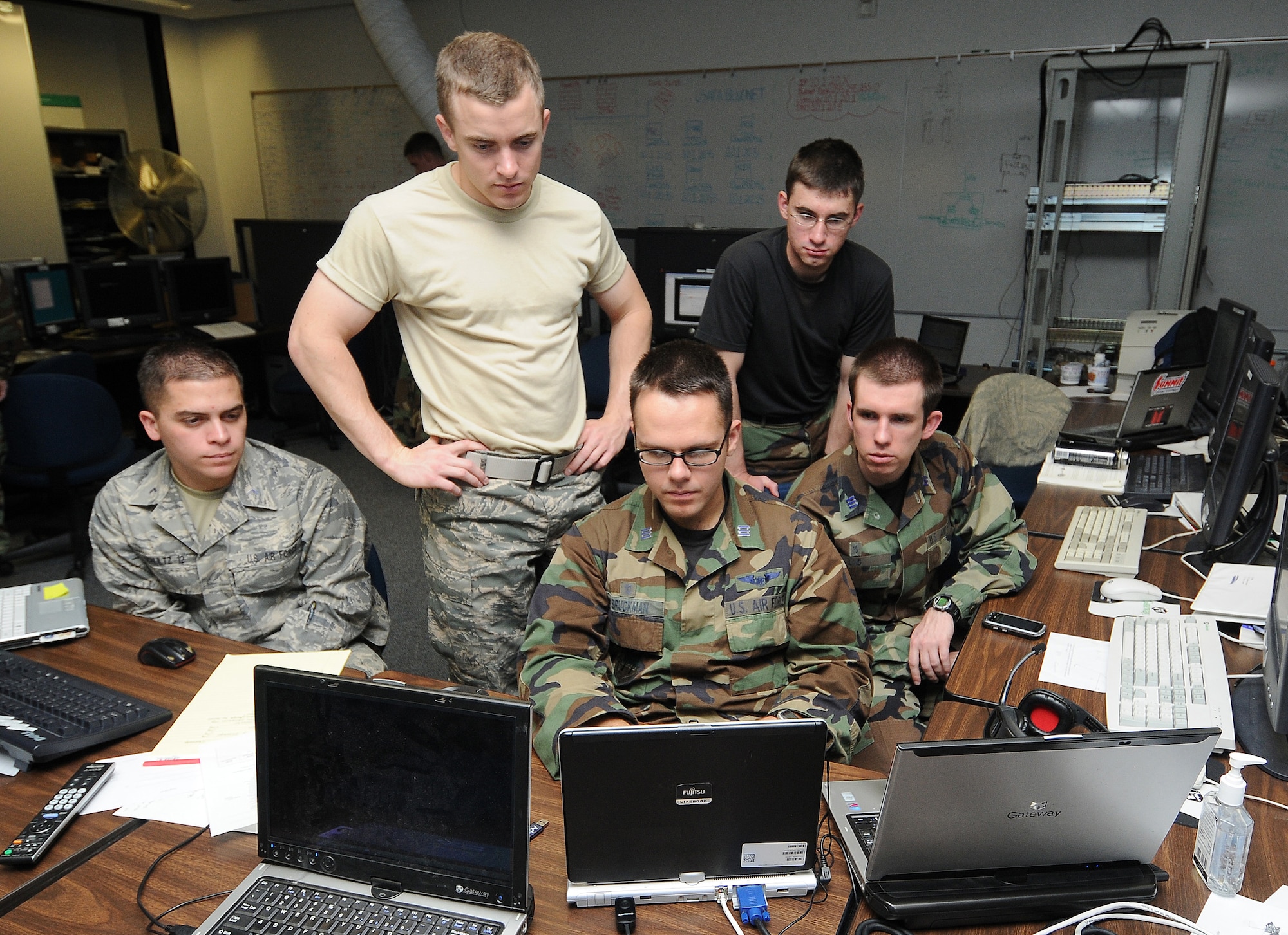 Cadet 3rd Class Tyler Schultz and Cadets 1st Class Anthony Blankenberger, Benjamin Bruckman, Jase Garcia and Jesse Lind gather around to watch proceedings during the National Security Agency's 2010 Cyber Defense Exercise at the U.S. Air Force Academy April 22. Cadets in the exercise built a network and had to defend it from NSA aggressor teams' attacks. (U.S. Air Force photo/Rachel Boettcher)