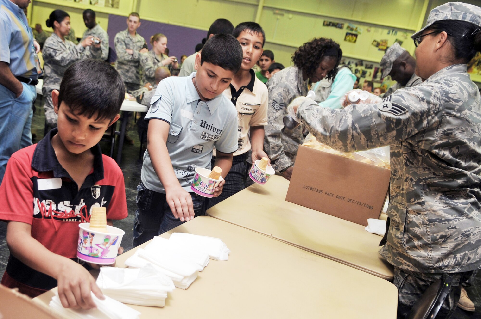 Members of the 332nd Expeditionary Force Support Squadron serve ice cream to Iraqi children during Iraqi Kids Day April 24, 2010, at Joint Base Balad, Iraq. (U.S. Air Force photo/Senior Airman Brittany Y. Bateman)