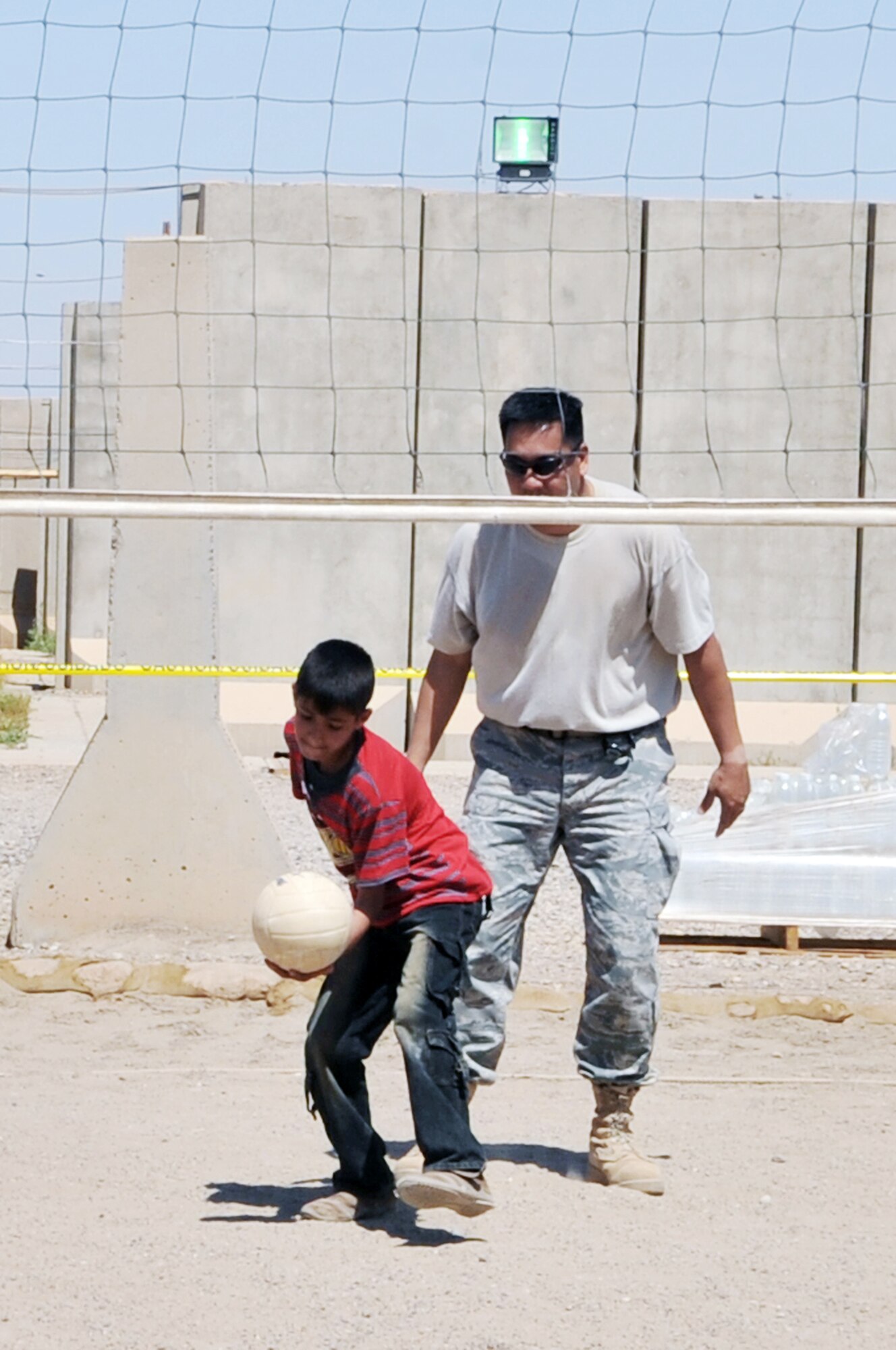 Tech. Sgt. Joseph Ferrer plays volleyball with an Iraqi boy during Iraqi Kids Day at Joint Base Balad, Iraq, April 24, 2010. Sergeant Ferrer is a 332nd Expeditionary Civil Engineer Squadron construction manager. (U.S. Air Force photo/Senior Airman Brittany Y. Bateman)