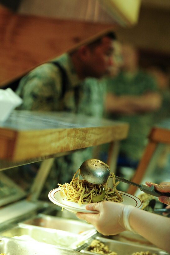ELLSWORTH AIR FORCE BASE, S.D.- Airman 1st Class Steffanie Whipple, 28th Force Support Squadron food service apprentice, scoops yakisoba onto a plate for an Airman at the Bandit Inn Dining Facility, April 27.  The Air Force operates more than 270 dining facilities and flight kitchens worldwide. (U.S. Air Force photo/Airman 1st Class Corey Hook)