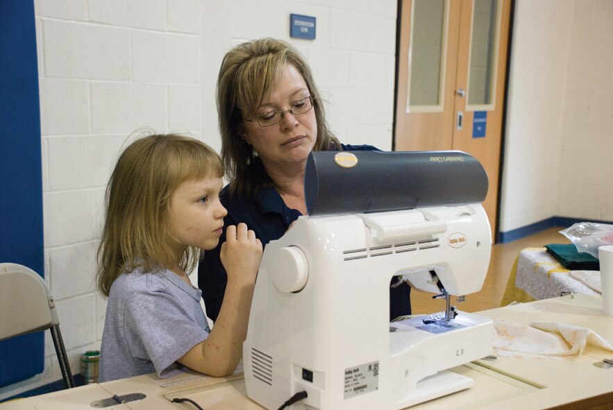 SCOTT AIR FORCE BASE, Ill. -- Zoe Macintyre, 6, learns how to operate a sewing machine with Ruthie Craig, Youth Center assistant. (U.S. Air Force Photo by Steve Berry) 
