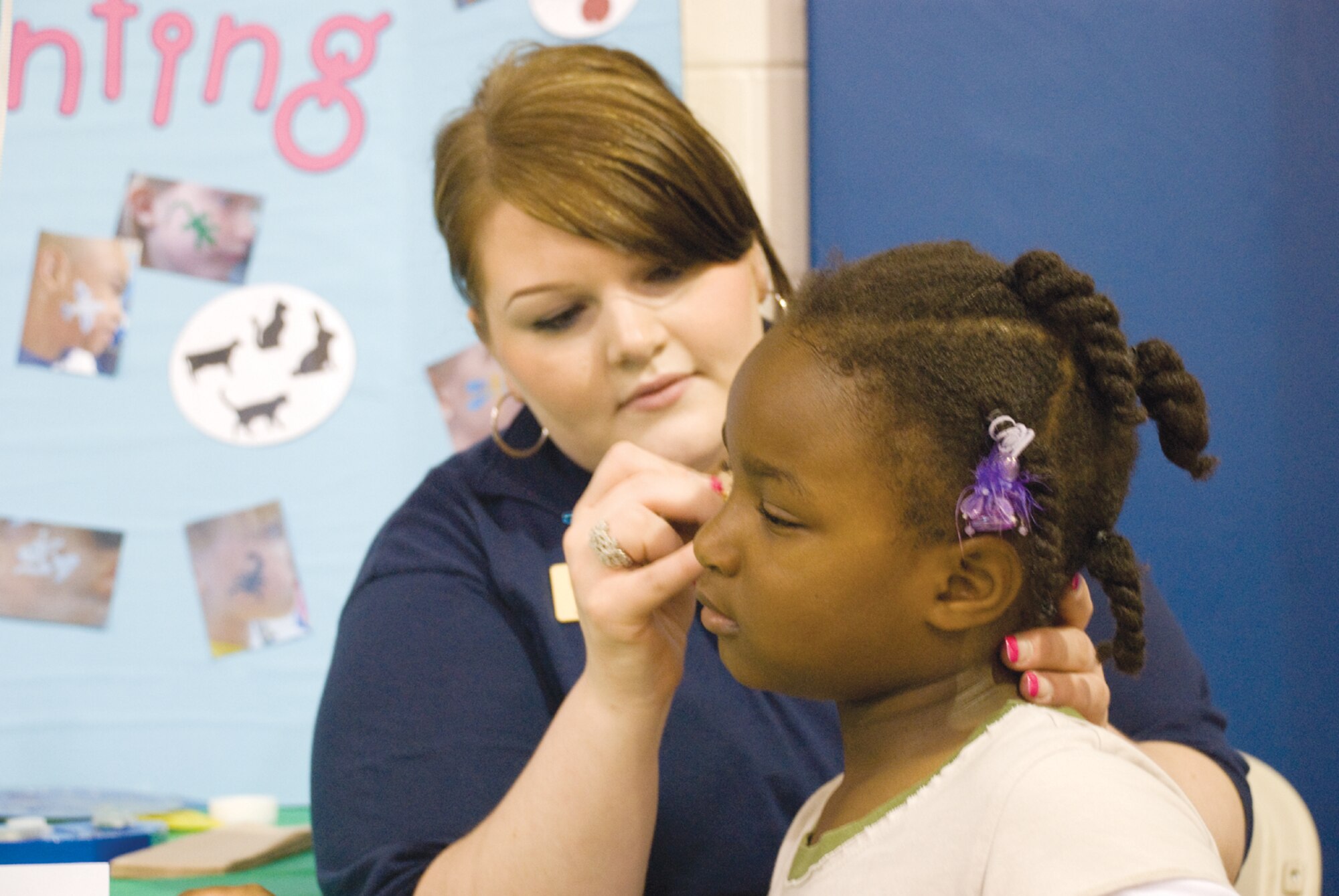 SCOTT AIR FORCE BASE, Ill. -- Kaylee Ballard, 6, has her face painted by Lacy Zidzik, Youth Center assistant. (U.S. Air Force Photo by Steve Berry) 