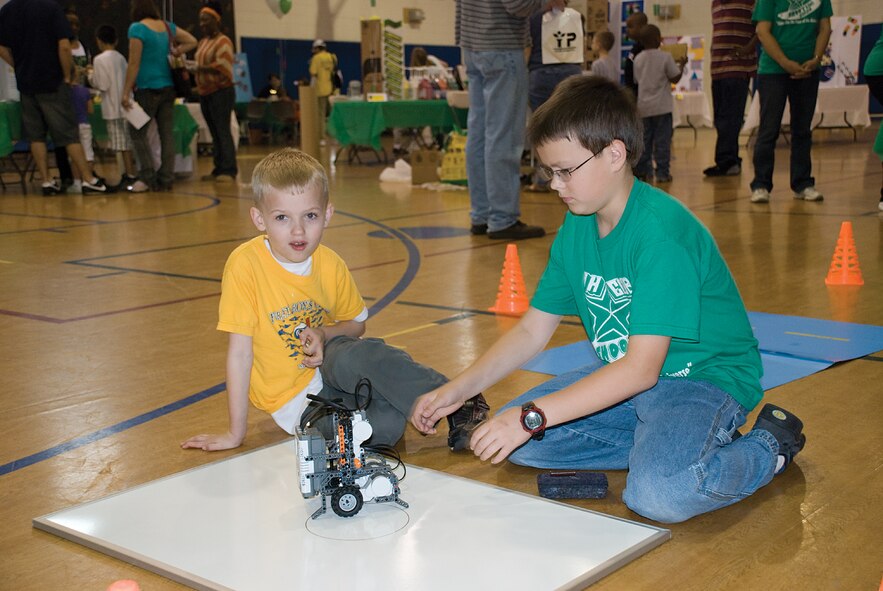 SCOTT AIR FORCE BASE, Ill. -- Joe Phillips, 11, (right) shows Ethan Bortvit, 7, how to operate a robot.  Joe is a member of the Shooting Stars 4-H club, which meets in Fairview Heights, Ill. (U.S. Air Force Photo by Steve Berry) 