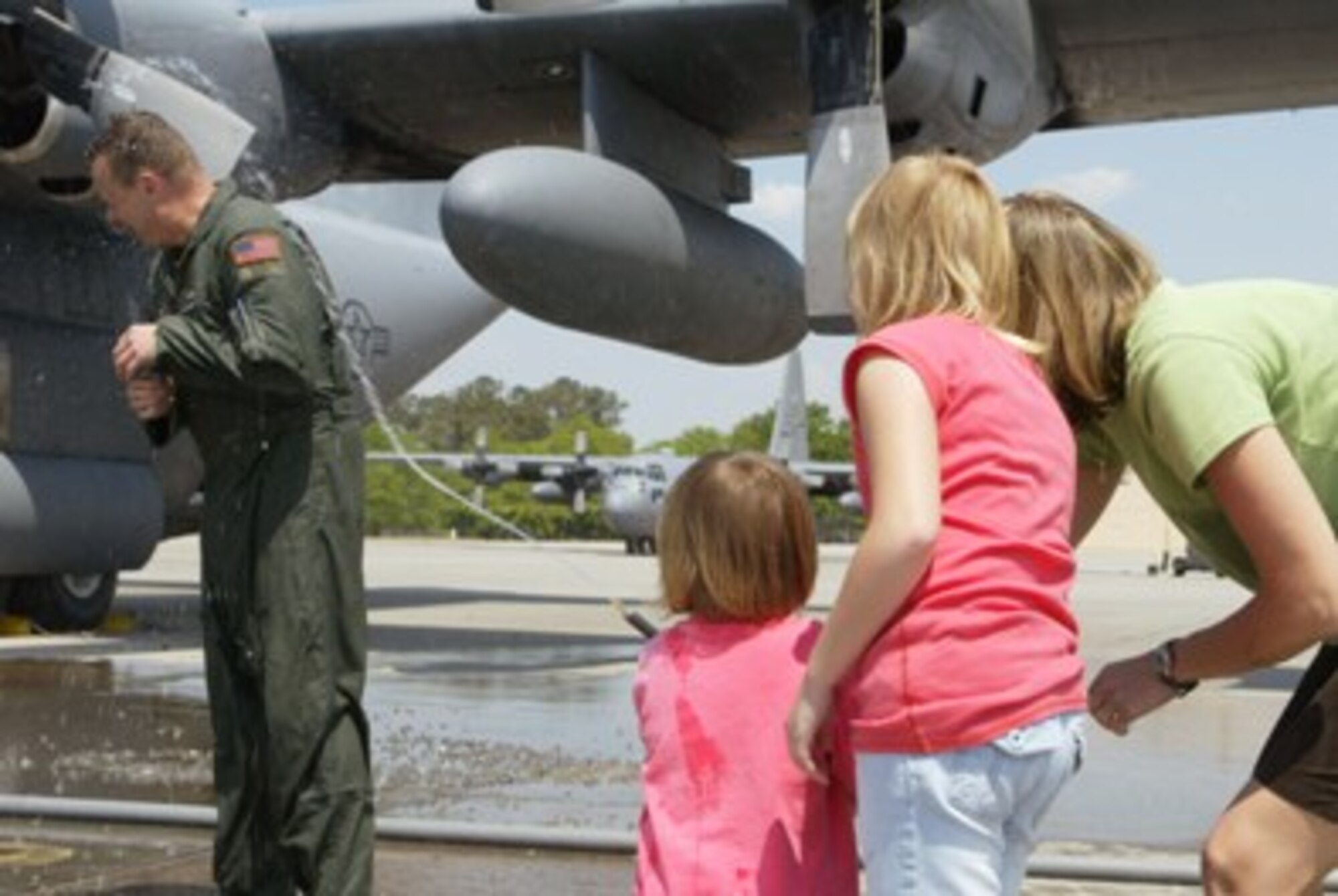 After a good soaking from his crew, Senior Master Sgt. John L. Grutzmacher,  Loadmaster from the 700th Airlift Squadron, receives the final spray from his family, wife Ingrid and daughters Jenna and Addison at his fini-flight here Apr. 16. Grutzmacher is leaving for his new assignment with 96th Airlift Squadron, 934th Airlift Wing, Minneapolis, Minn.