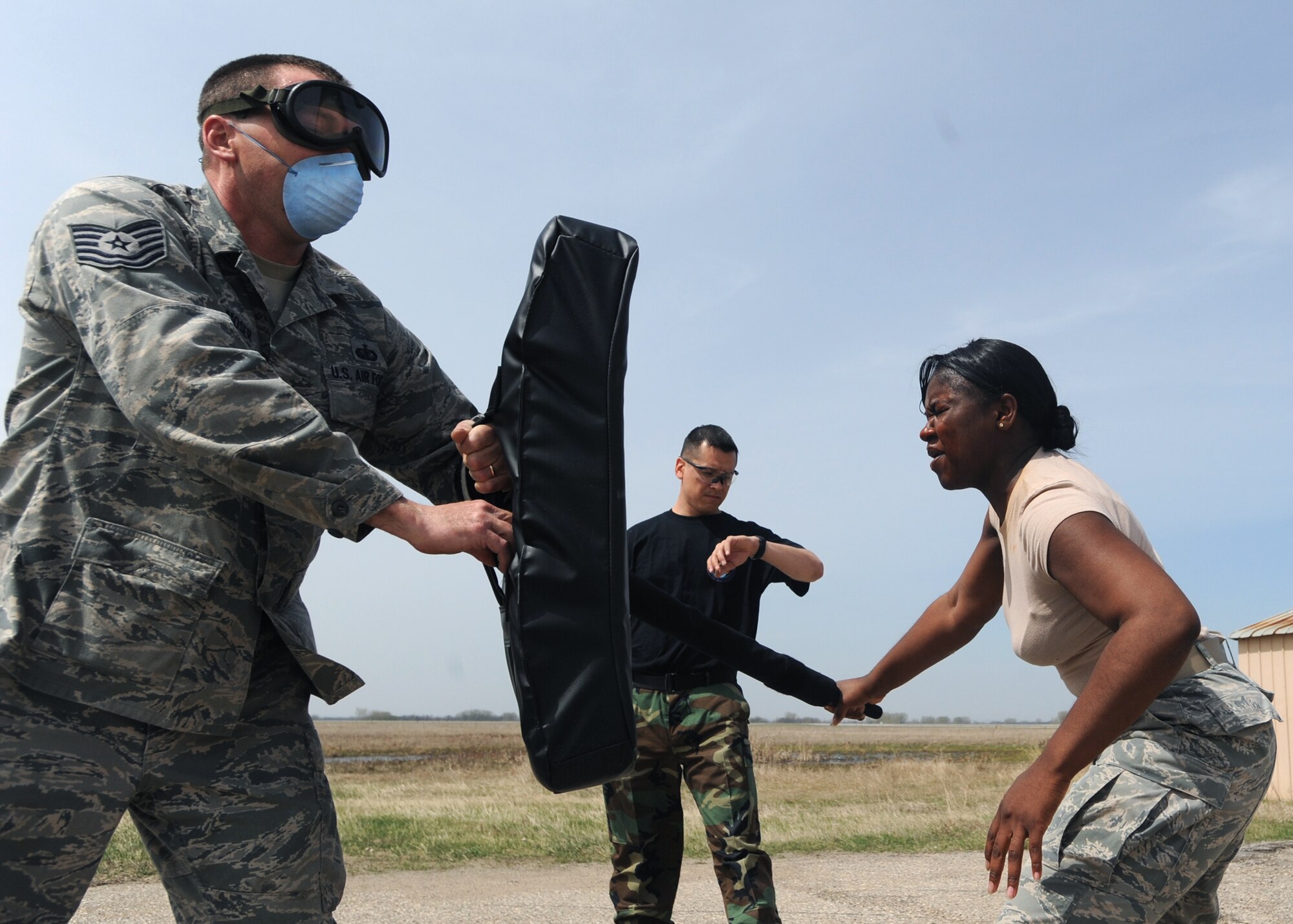 Staff Sgt. Jose Favela, 319th Security Forces Squadron, observes Airman 1st Class Kaleea Benjamin, 319th SFS as she performs her riot baton techniques after being exposed to oleoresin capsicum April 23 on Grand Forks Air Force Base, N.D. Airman Benjamin must be experienced with OC to be a certified handler. The Intra Service Non-Lethal Weapon training course serves two purposes, first, knowing what it’s like if exposed and second, knowing how to handle a suspect when exposed to OC. (U.S. Air Force photo by Airman 1st Class Amber Price)