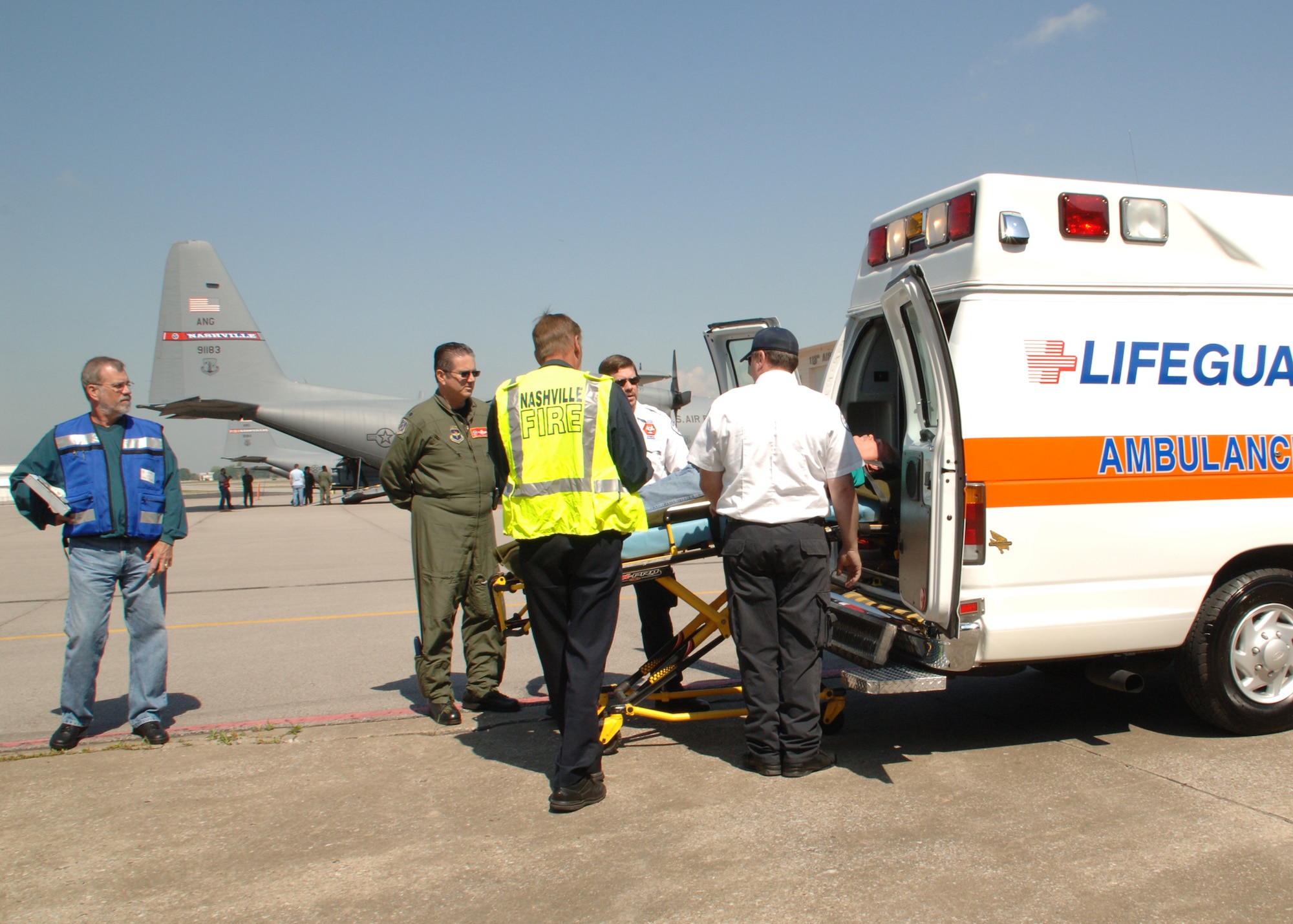 A patient is loaded into an ambulance to be transported to a nearby hospital. Once the patients reach the hospital, the drill is over. They are delivered by a bus back to the base so they can return home.