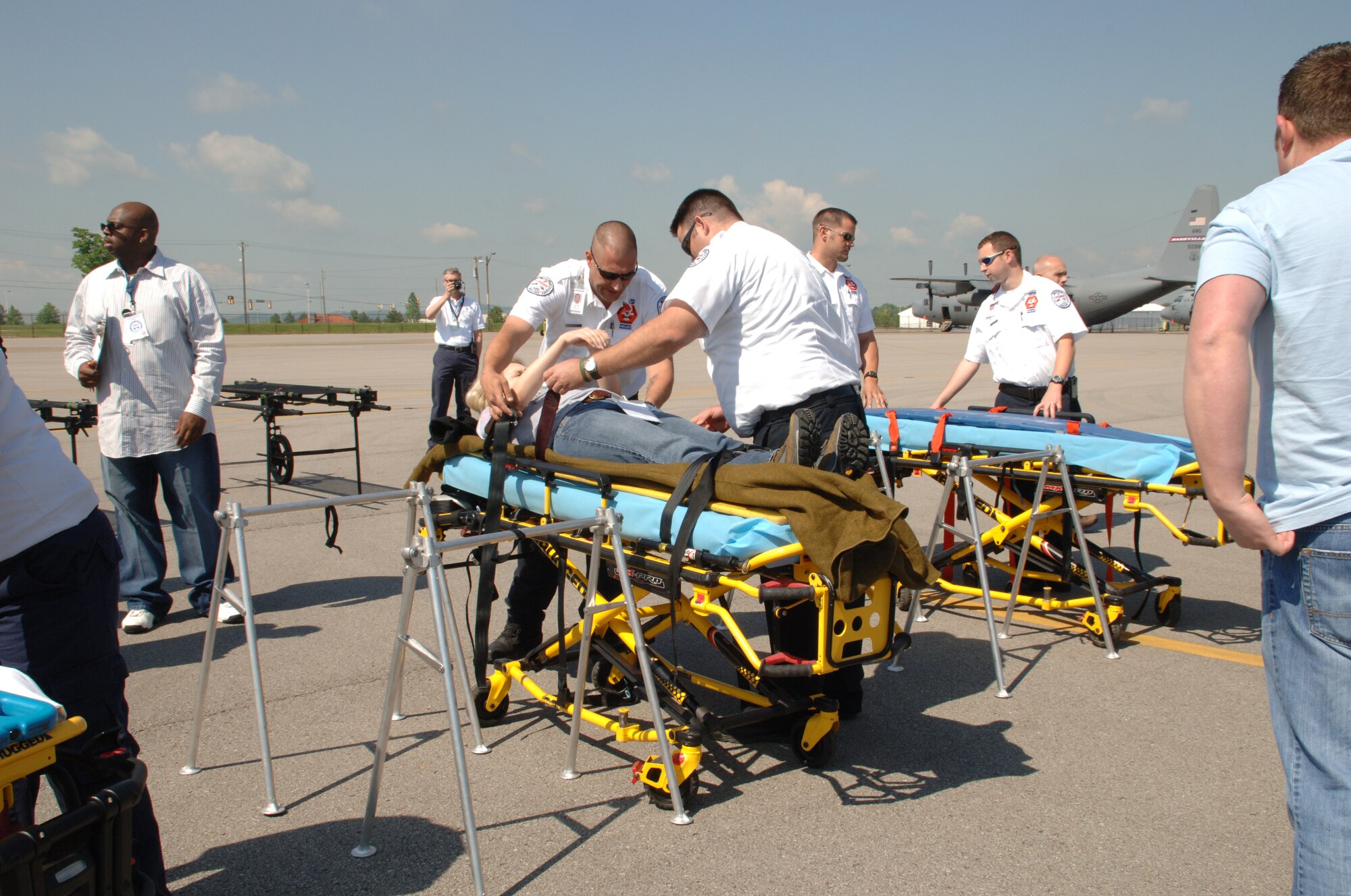 Ambulance staff fasten a volunteer 'victim' to a gurney.