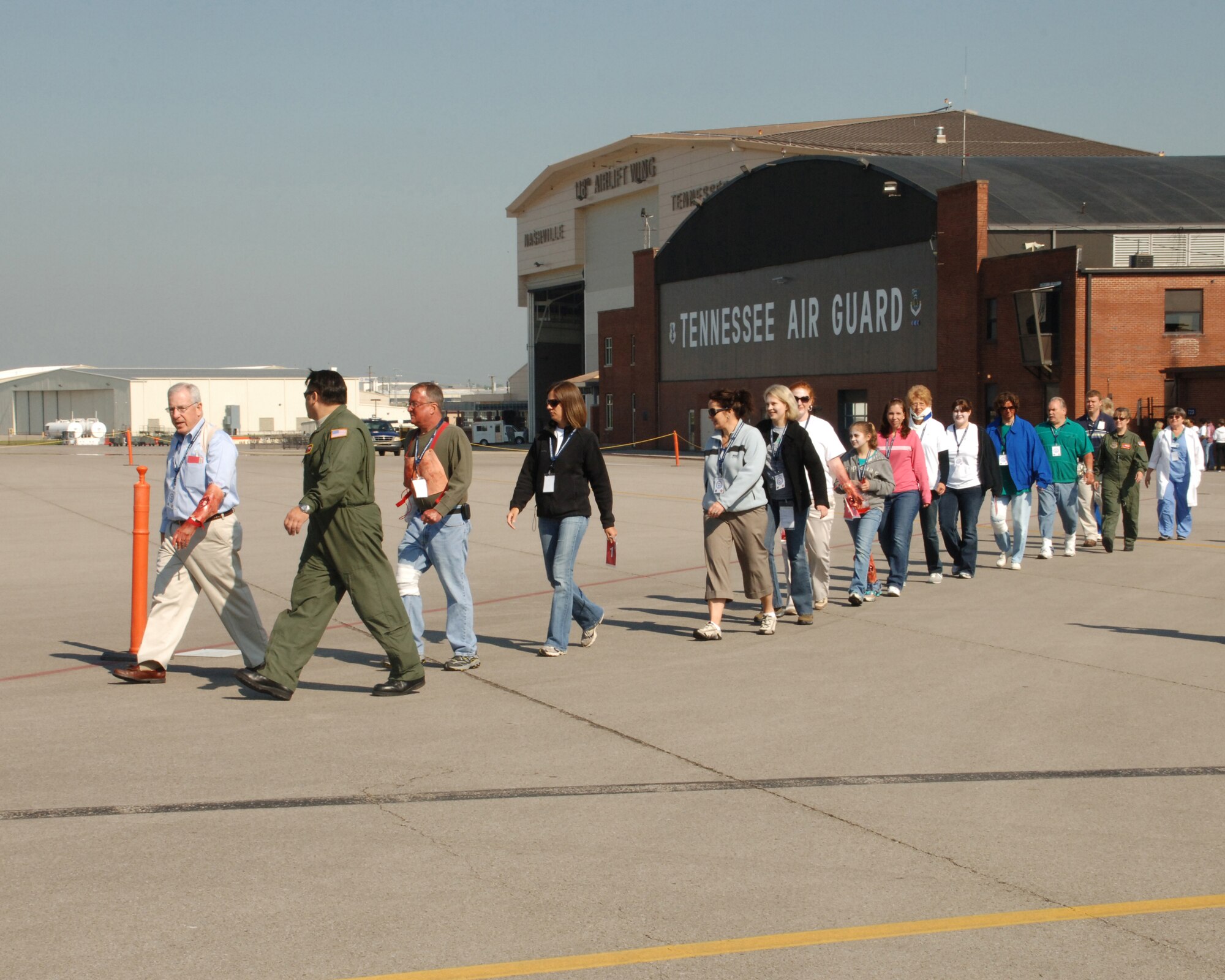 A group of triaged patients walks to a C-130 aircraft, preparing for the start of the National Disaster Medical System Exercise that took place at the 118th Airlift Wing April 28.
