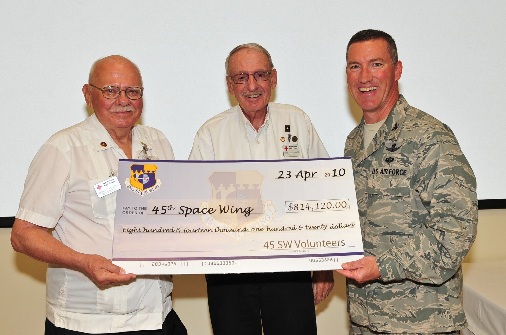 Red Cross Volunteers Dean Carlson (left) and Burt Slesinger present 45th Space Wing
Commander Col. Ed Wilson with a check for the $814,120 volunteers saved the Wing in 2009 at the annual Volunteer Appreciation Week Ice Cream Social at the Airman
& Family Readiness Center April 23. After accepting the check, Colonel Wilson presented Volunteer Excellence Awards to Candice Graves, Trudy Hughes and Michael McAleenan for their work with various Wing and community activities. (U.S. Air Force photo/Jennifer Macklin)