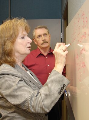 PDMC flight chief Diane Nichols and forward demand planner Dan Winters discuss customers’ needs. The new flight of the 428th SCMS is a focal point to consolidate requirements for DLA-managed parts numbering in the thousands. These parts can be as large as structural support for a KC-135 aircraft as well as something as small as a screw for any general purpose application. This new flight collaborates with DLA to improve the flow of parts from supplier to customer. (Air Force photo by Margo Wright)