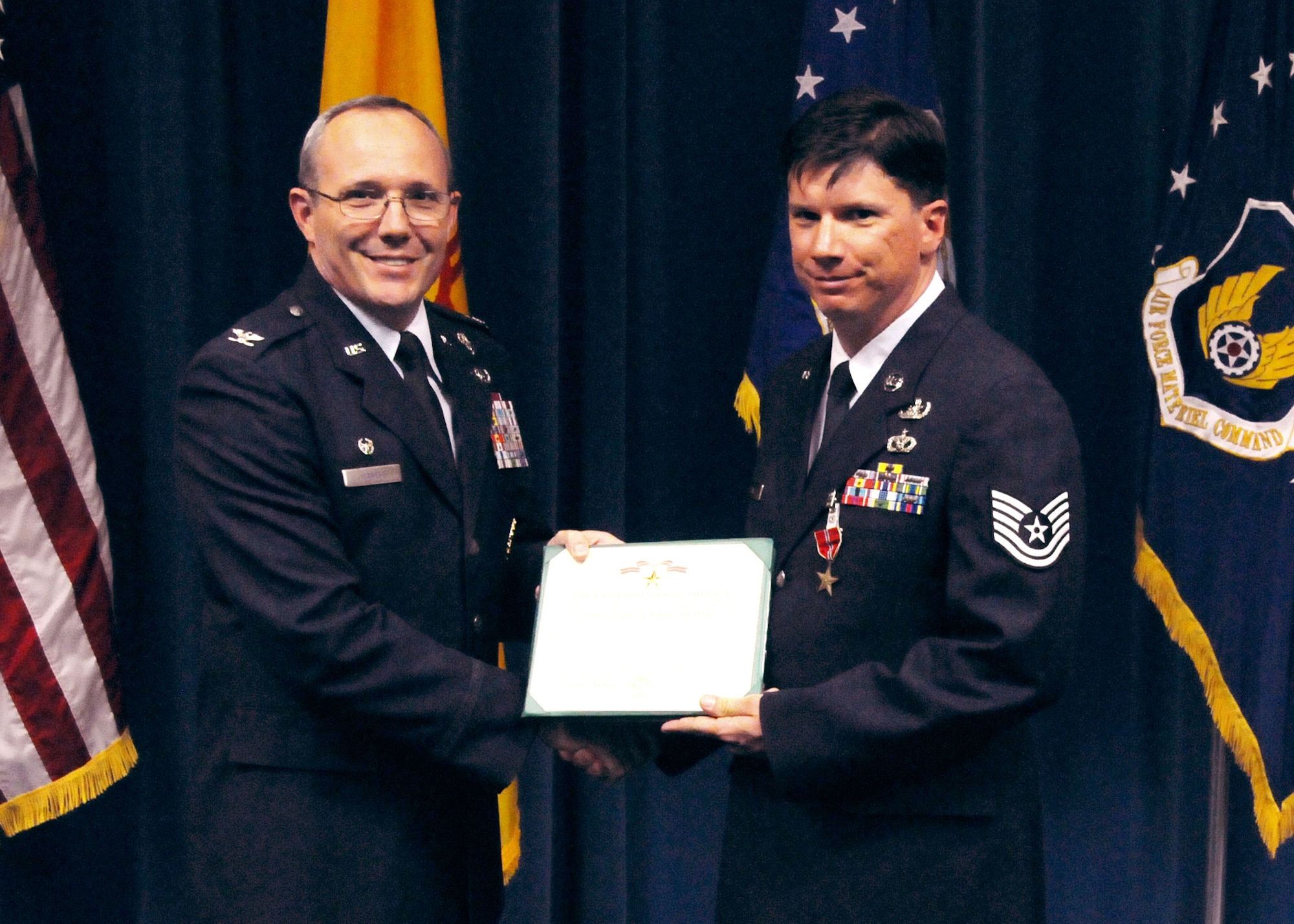 Col. Robert Maness, 377th ABW Commander presents Tech. Sgt. Albert Jewell, 377th MSG/EOD with the Bronze Star at a ceremony at the Wing Presentation Center on April 26th. U.S. Air Force Photo by Dennis Carlson