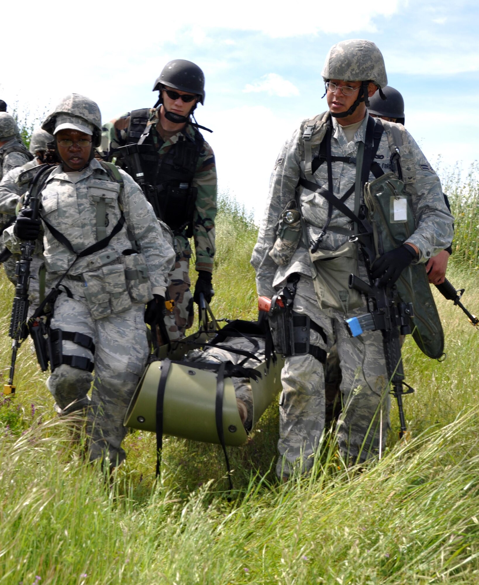 Air Force security forces and Navy Master of Arms (Navy police,) evacuate an injured Airman out of a combat zone during an exercise at Camp Park Reserve Force Training Area in Dublin, Calif. (U.S. Air Force photo/Airman 1st Class Michael Battles)