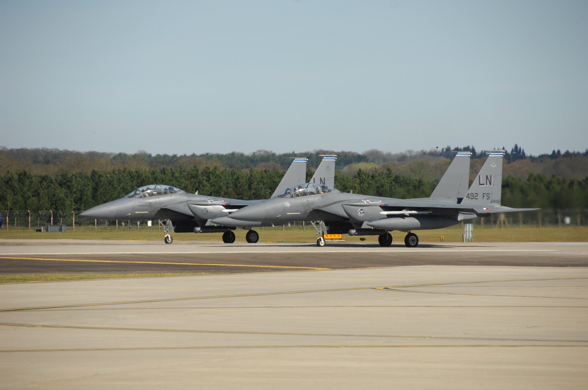 Two F15-E aircraft from the 492nd Fighter Squadron, RAF Lakenheath, England, prepare to take off for normal flying operations here April 26. Over the next few weeks, various aircraft will temporarily relocate to RAF Mildenhall, England, in preparation for the airfield closure at RAF Lakenheath. The relocation is due to construction on the runway and adjoining taxiways at RAF Lakenheath that will take approximately one month to complete. (U.S. Air Force photo/Tech. Sgt. Christopher Campbell)