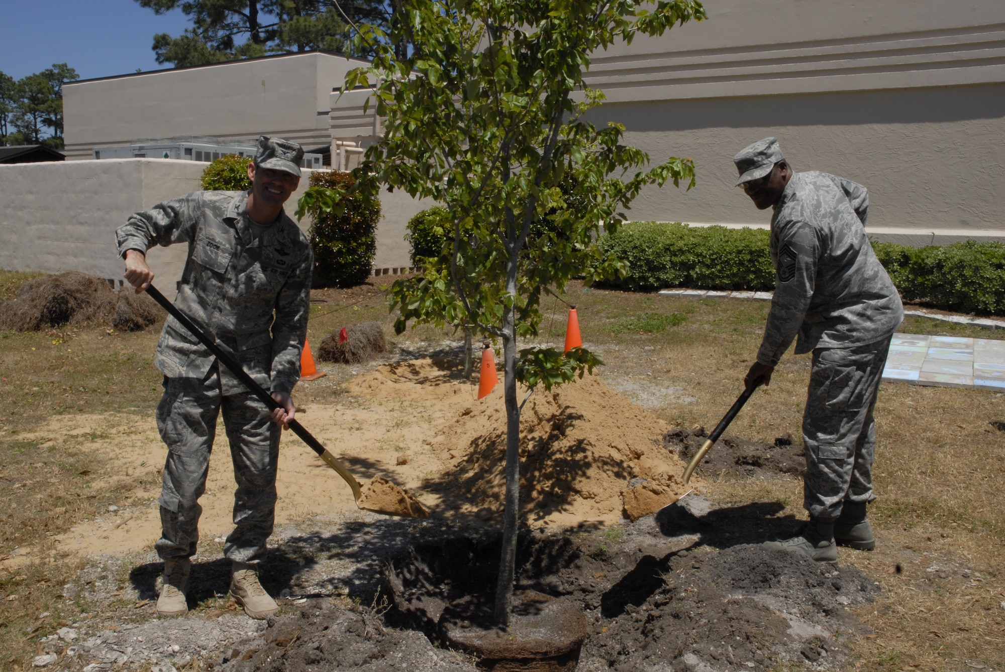 Col. Daniel Zook, 1st Special Operations Wing vice commander, left, and Chief Master Sgt. Aubrey Harvey, 1st Special Operations Force Support Squadron superintendent, plant a maple tree during the Arbor Day ceremony at the Hurlburt Field Library April 28. The tree was planted next to the library's tree circle and outdoor classroom. (DoD photo by U.S. Air Force Airman 1st Class Joe McFadden)