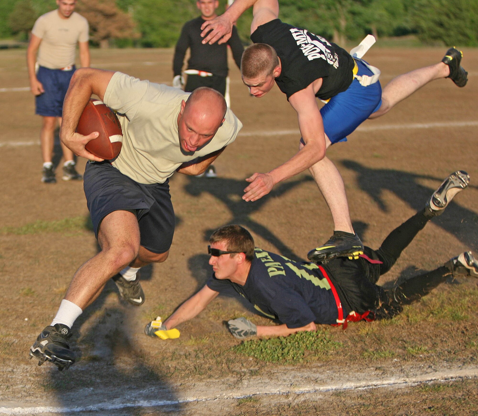 Receiver Stephen Foster, with the 32nd CCS, dodges 552nd MXS defenders while running downfield April 27. Foster helped his team to a win with one touchdown as they topped 552nd MXS 24-21.  (Air Force photo by John Stuart)