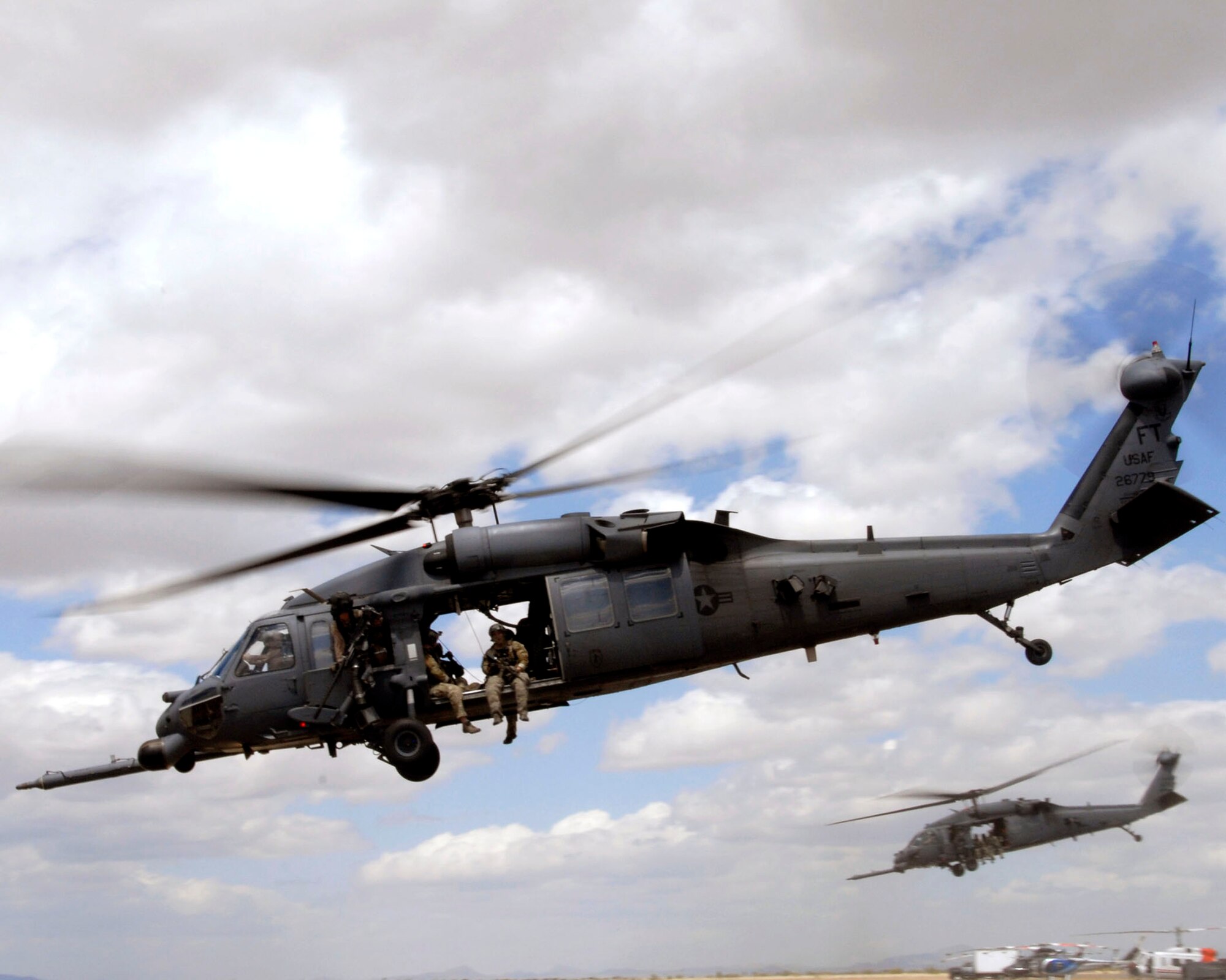Two HH-60G Pave Hawk rescue helicopters participating in Exercise Angel Thunder 2010 take off to rescue survivors of an exercise scenario April 21, 2010, at Bisbee-Douglas International Airport in Ariz. (U.S. Air National Guard photo/Airman 1st Class Jessica Green)