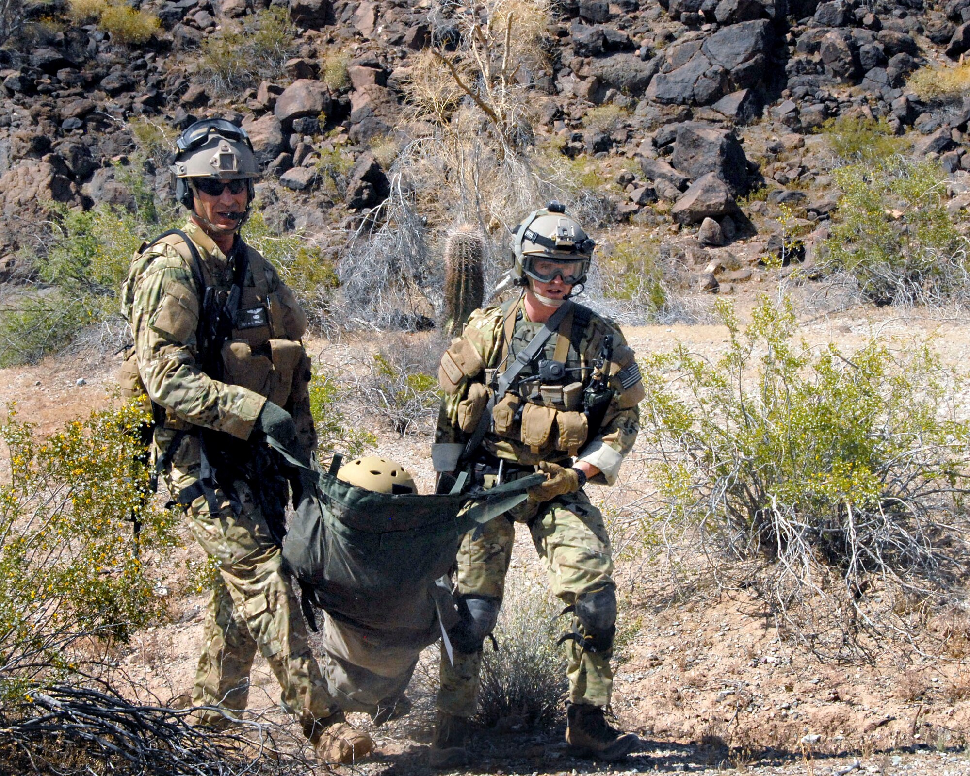 Pararescuemen participating in an Exercise Angel Thunder 2010 combat search and rescue mission carry a volunteer survivor to the HH-60G Pave Hawk rescue helicopter at the Barry M. Goldwater range April 18, 2010, in the Sonoran Desert in Ariz. (U.S. Air National Guard photo/Airman 1st Class Jessica Green)