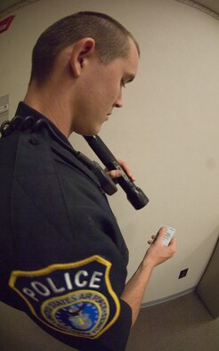 Officer Joshua Johnson, 22nd Security Forces Squadron patrolman, demonstrates the use of the Passive Alcohol Sensor IV on a common access card April 28, 2010, McConnell Air Force Base, Kan. The PAS IV senses the alcohol through small silent pump located near the mouth of the light that draws an air sample when a person speaks. (U.S. Air Force photo/Senior Airman Abigail Klein)