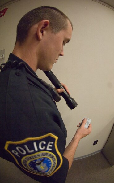 Officer Joshua Johnson, 22nd Security Forces Squadron patrolman, demonstrates the use of the Passive Alcohol Sensor IV on a common access card April 28, 2010, McConnell Air Force Base, Kan. The PAS IV senses the alcohol through small silent pump located near the mouth of the light that draws an air sample when a person speaks. (U.S. Air Force photo/Senior Airman Abigail Klein)