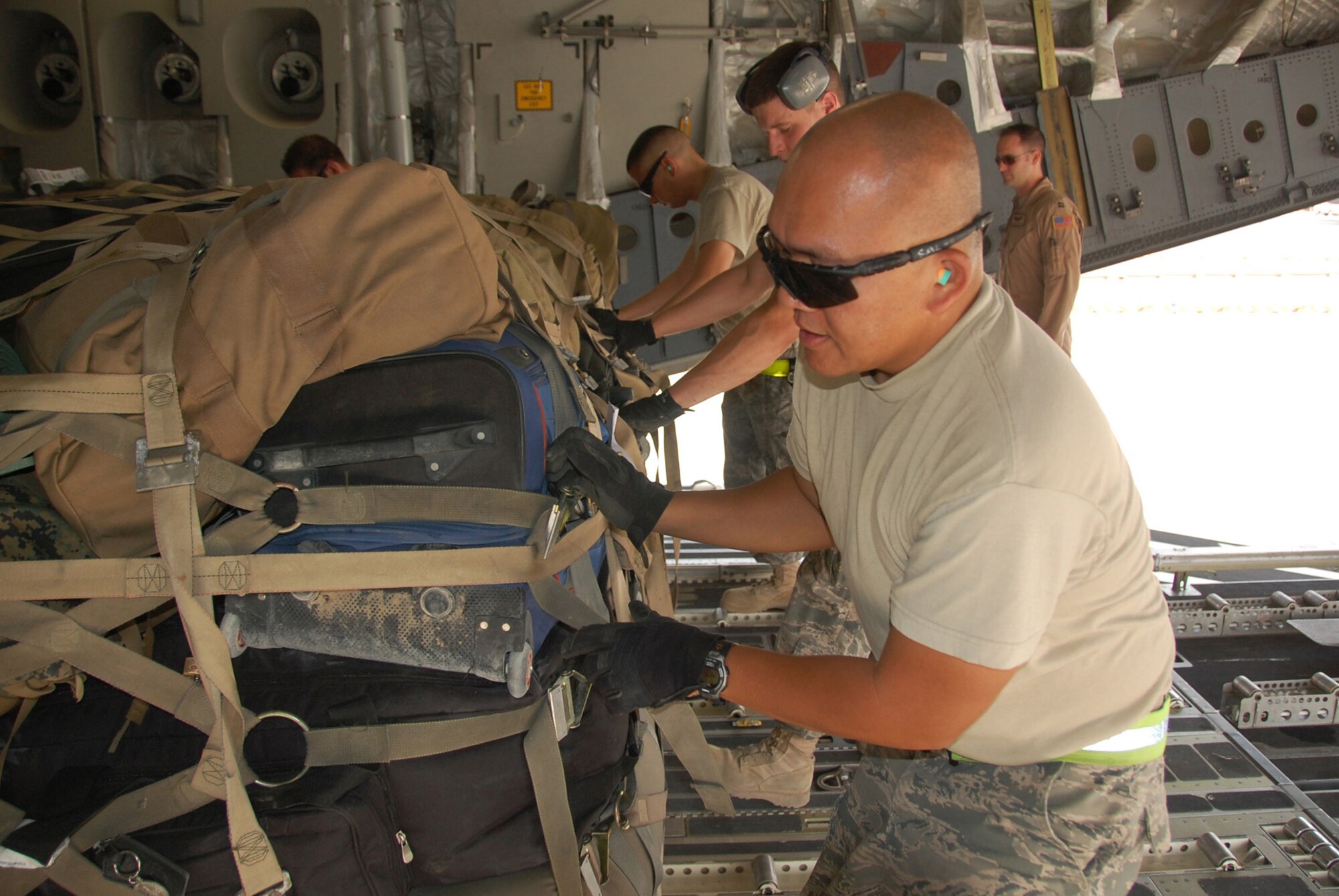 U.S. Air Force Tech. Sgt. Domingo Sales, front, and fellow 386th Expeditionary Logistics Readiness Squadron Aerial Port Airmen load a 463L baggage pallet onto a C-17 Globemaster April 27, 2010 at an undisclosed location in Southwest Asia. The 386th ELRS Aerial Port team works around the clock, processing an average of 60,000 passengers and five and a half tons of cargo in and out of the U.S. Central Command area of responsibility a month. (U.S. Air Force photo by Tech. Sgt. Lindsey Maurice/Released)