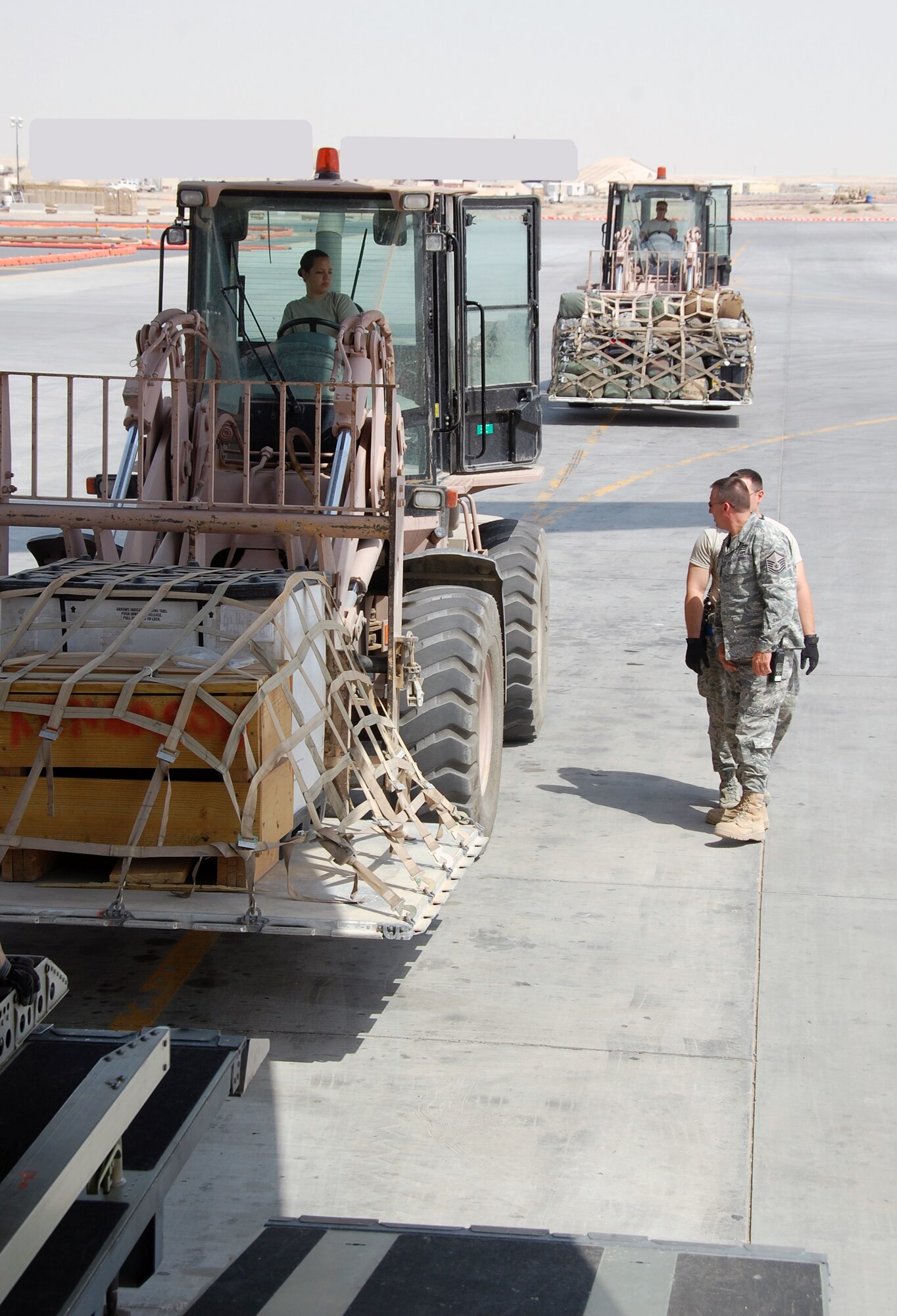 U.S. Air Force Senior Airman Danielle Bolia of the 386th Expeditionary Logistics Readiness Squadron Aerial Port loads a 463L cargo pallet onto a C-17 using a 10K AT forklift April 27, 2010 at an undisclosed location in Southwest Asia. The 386th ELRS Aerial Port team works around the clock, processing an average of 60,000 passengers and five and a half tons of cargo in and out of the U.S. Central Command area of responsibility a month. (U.S. Air Force photo illustration by Tech. Sgt. Lindsey Maurice/Released)