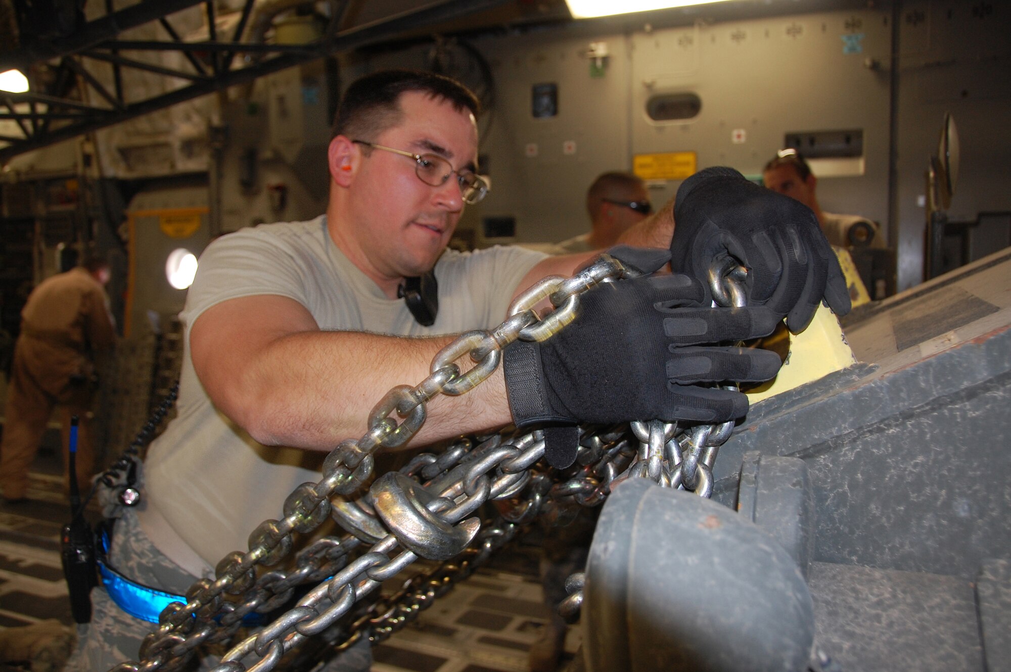 U.S. Air Force Staff Sgt. Jeffery Kach of the 386th Expeditionary Logistics Readiness Squadron Aerial Port secures a vehicle in the back of a C-17 Globemaster April 27, 2010 at an air base in Southwest Asia. The 386th ELRS Aerial Port team works around the clock, processing an average of 60,000 passengers and five and a half tons of cargo in and out of the U.S. Central Command area of responsibility a month. (U.S. AIr Force photo by Tech. Sgt. Lindsey Maurice/Released)
