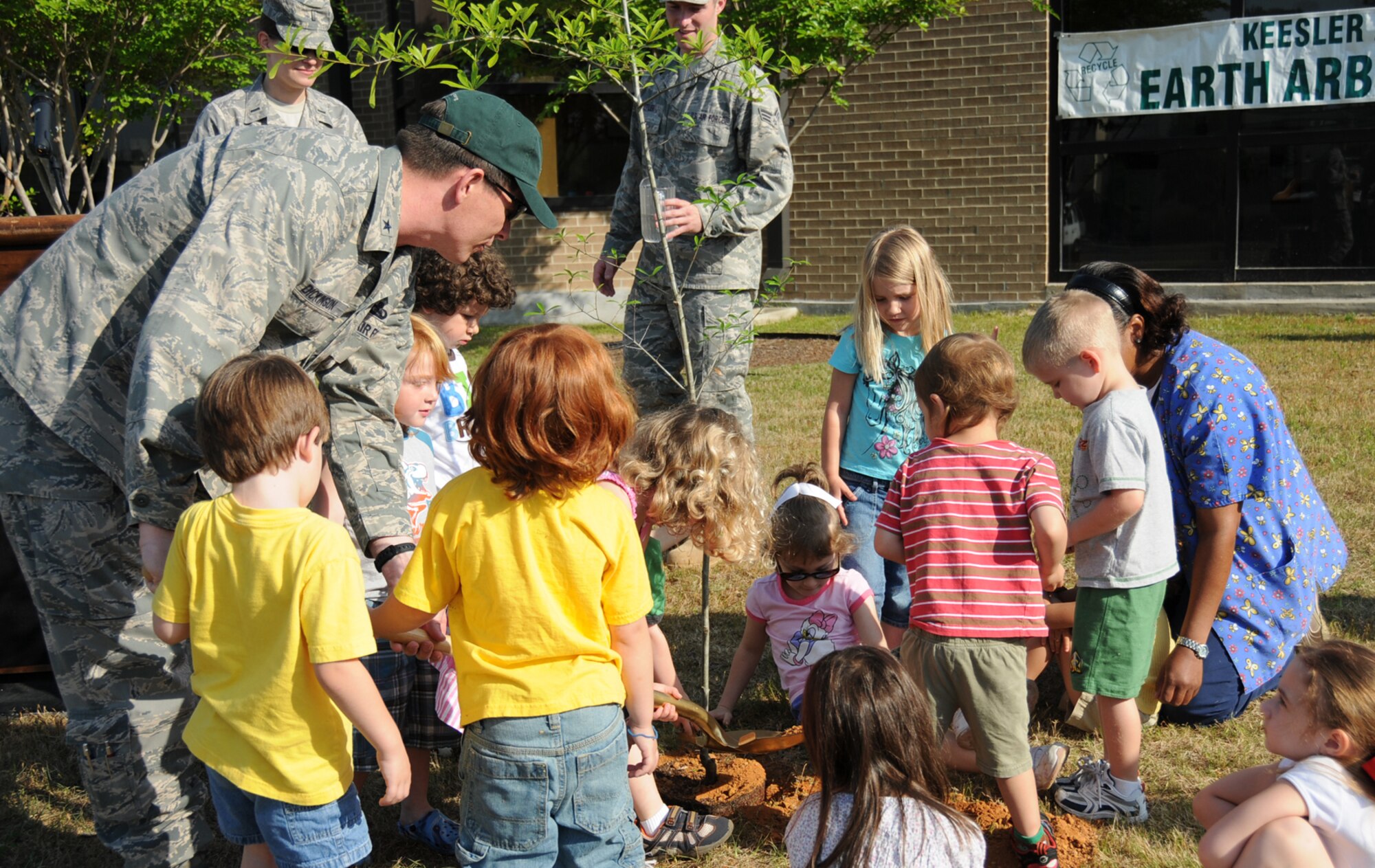 Brig. Gen. Ian Dickinson, 81st Training Wing commander, and children from the child development center plant a native water oak to celebrate Earth Arbor Day April 22. (U.S. Air Force photo by Kemberly Groue)