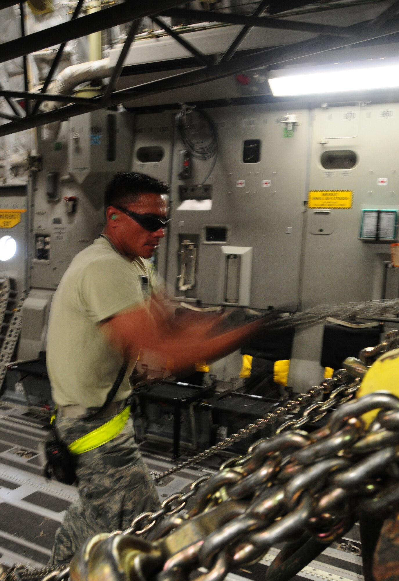 U.S. Air Force Senior Airman Alden Kaai of the 386th Expeditionary Logistics Readiness Squadron Aerial Port secures a piece of rolling stock on a C-17 Globemaster with chains April 27, 2010 at an undisclosed location in Southwest Asia. The 386th ELRS Aerial Port team works around the clock, processing an average of 60,000 passengers and five and a half tons of cargo in and out of the U.S. Central Command area of responsibility a month.(U.S. Air Force photo by Staff Sgt. Lakisha A. Croley/Released)