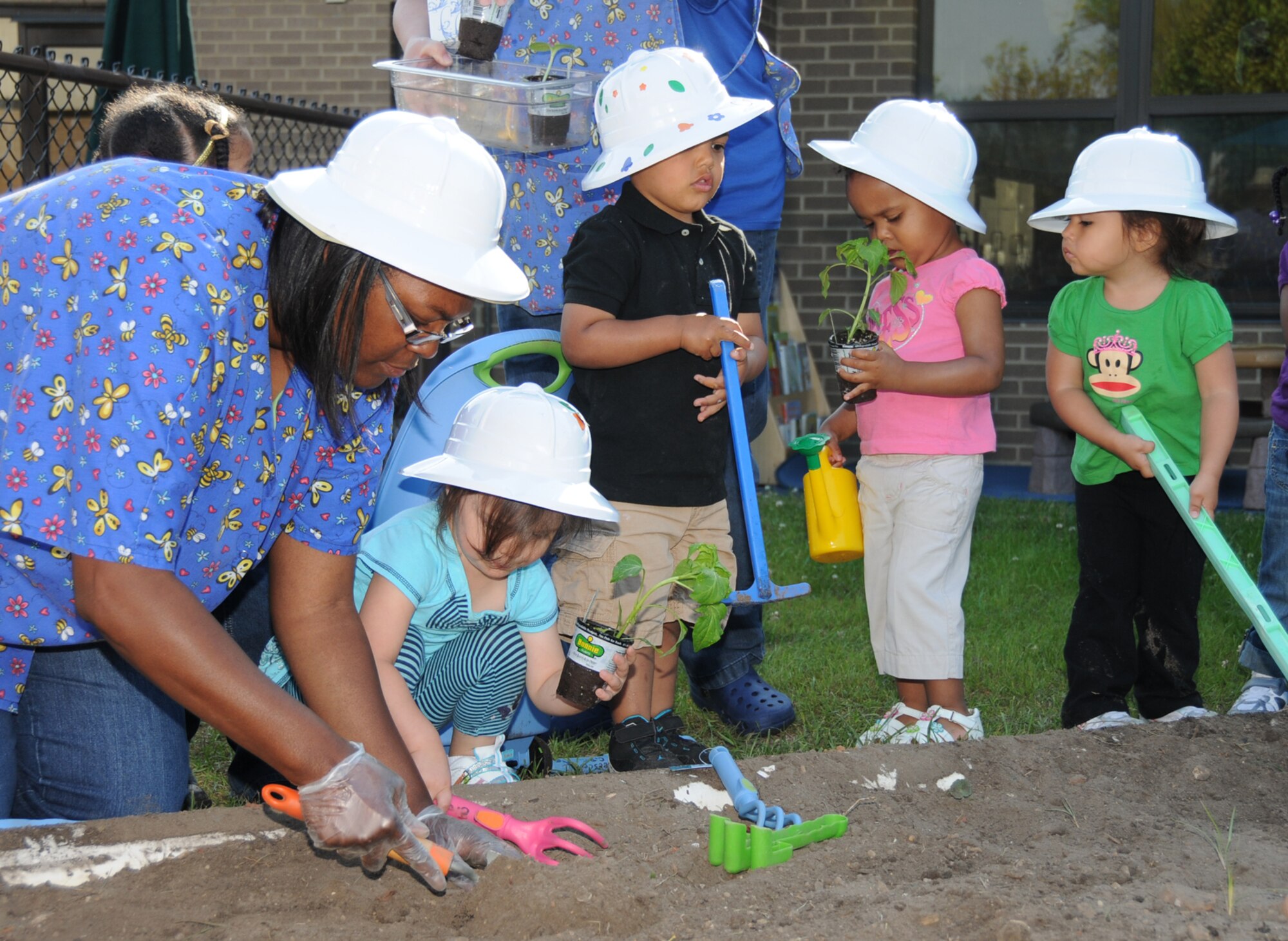 From left, Sadaki Lewis and 2-year-olds Skyler Castilleja, Christian Threatt, Tori Pearson and Tessa Garcia plant a vegetable garden at the child development center April 22 as part of Keesler’s Earth Arbor Day observance.  Skyler’s parents are Staff Sgt. Krystal Foster, 81st Diagnostics and Therapeutics Squadron, and John Castilleja.  Christian’s mom is Senior Airman Melissa Threatt, 81st Medical Operations Squadron.  Tori’s parents are Senior Master Sgt. Anthony Pearson, 334th Training Squadron, and Teri Johnsrud.  Tessa’s parents are Capt. Reynel and Melissa Garcia, 81st Medical Group.  (U.S. Air Force photo by Kemberly Groue)