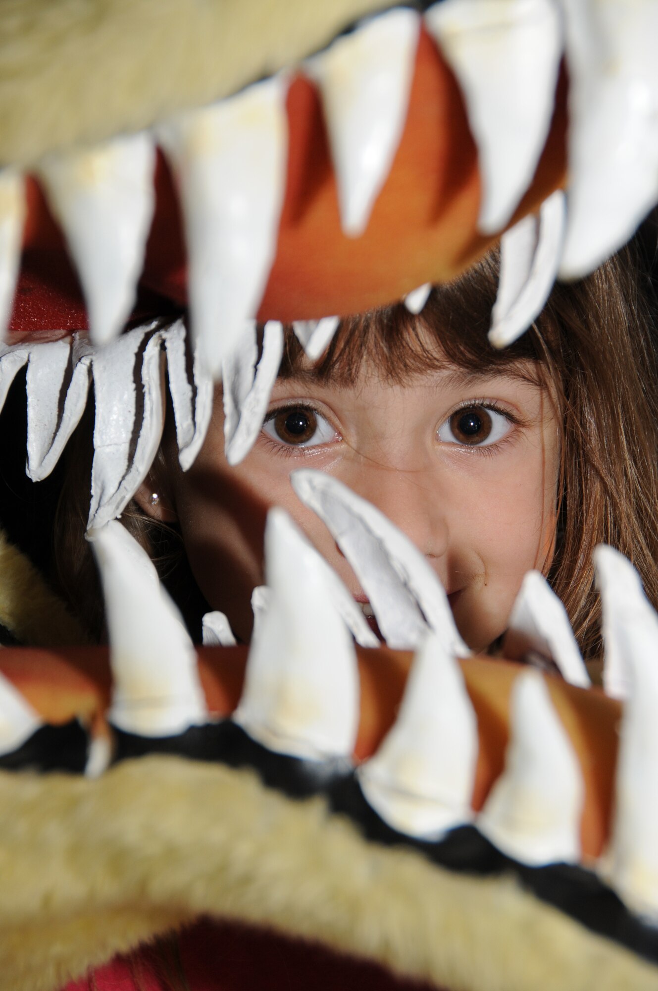 Trynity Novak, 6, peers through the jaws of the 334th Training Squadron’s Gator mascot.  Her mom is Staff Sgt. Jean Novak, 81st Diagnostics and Therapeutics Squadron.  (U.S. Air Force photo by Kemberly Groue)