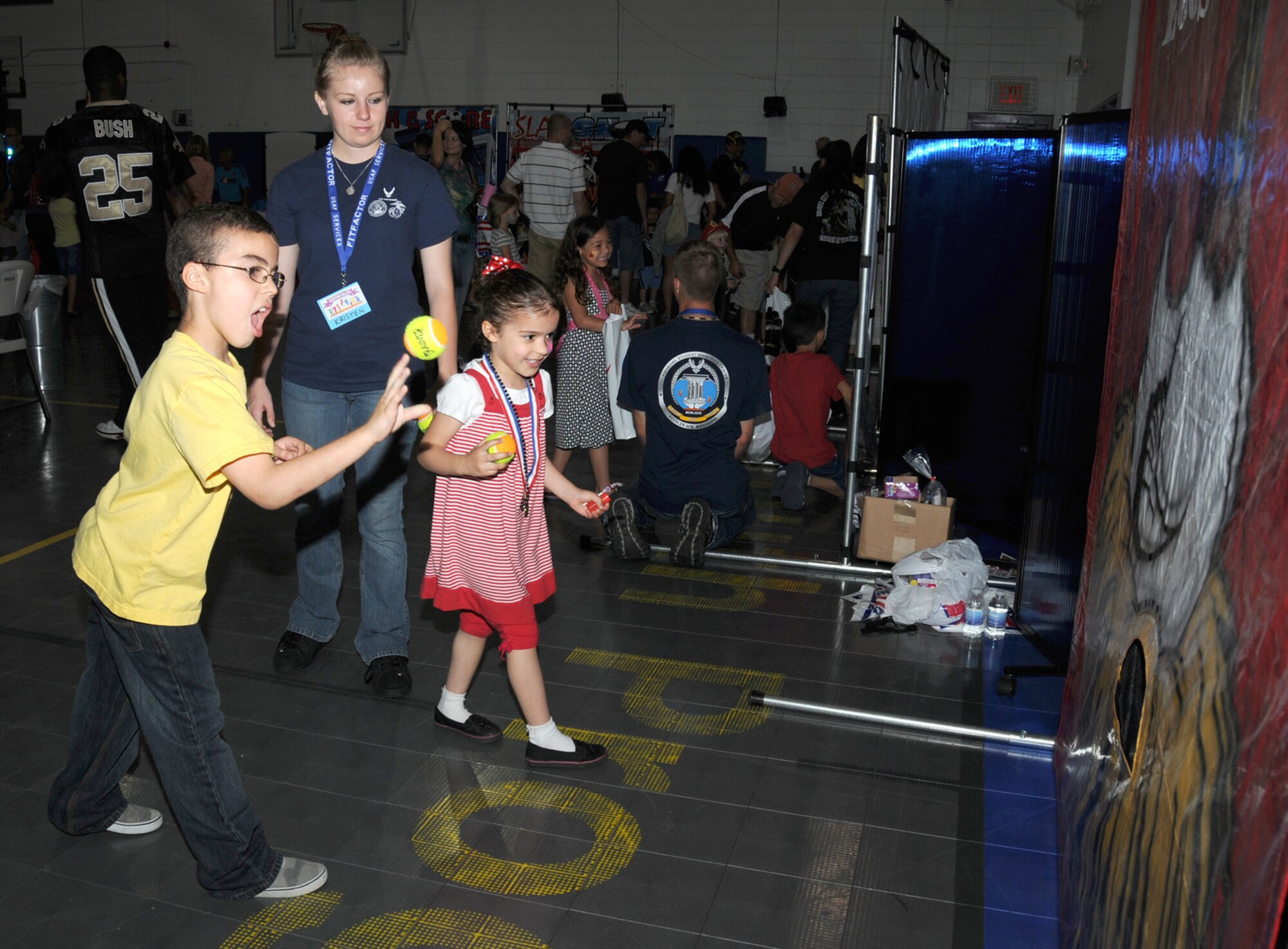 Airman Recruit Kristen Alexander from Keesler’s Center for Naval Aviation Technical Training Unit, watches as Kyle and Hayley Hancock play the scrambled eggs ball toss game.  Kyle, 7, and Hayley, 5, are the children of Master Sgt. Lukus and Argelia Hancock, 81st MSGS.  Sergeant Hancock is deployed.  (U.S. Air Force photo by Kemberly Groue)