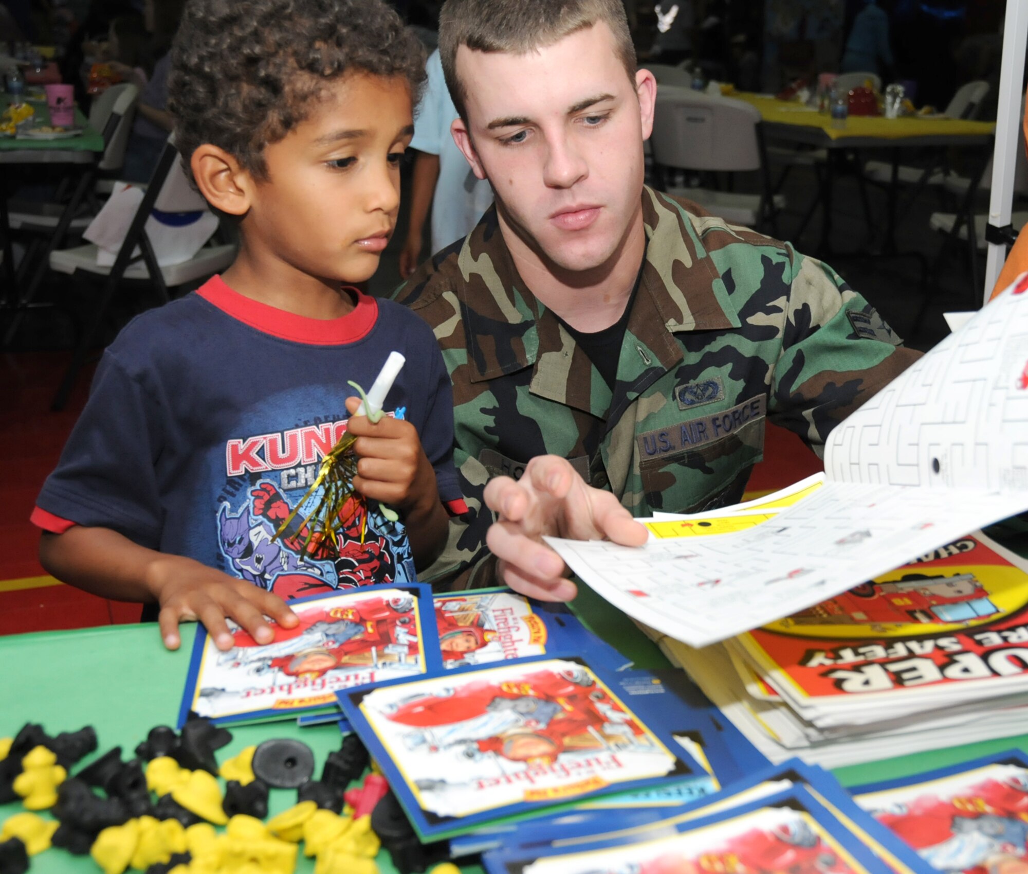 Brendan Kiprono, 5, son of Maj. Luissa and Ed Kiprono, 81st Surgical Operations Squadron, get some fire safety handouts from Airman 1st Class John Hood, a Keesler firefighter.  (U.S. Air Force photo by Kemberly Groue)