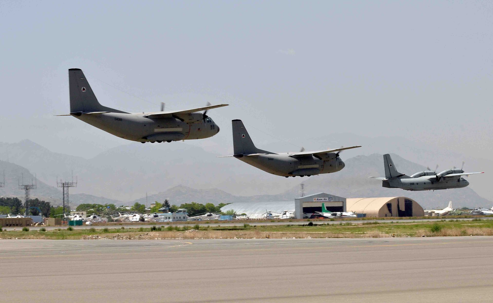 Afghan C-27 and AN-32 aircrews aircrews fly in formation above the flightline at the Afghan National Army Air Corps base in Kabul, Afghanistan April 28, 2010. The formation was part of an air show held in celebration of the "Mujahedeen Victory Day". (US Navy photo by Mass Communication Specialist 2nd Class David Quillen/ RELEASED)