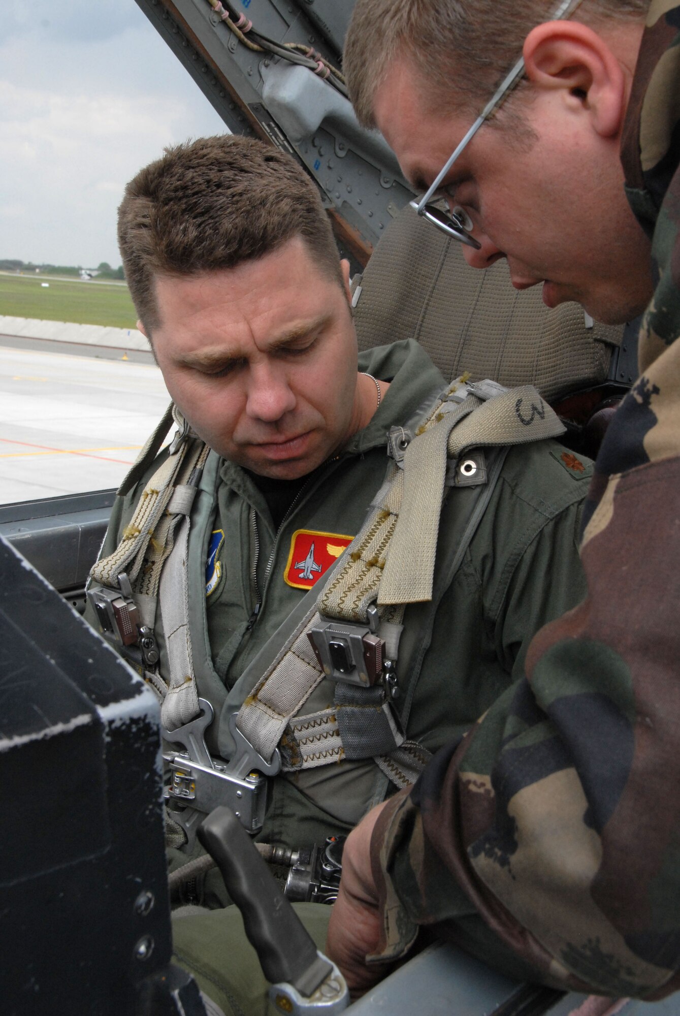 KECSKEMET, Hungary -- Maj. Keith Buddelmeyer, a F-16 instructor pilot with the 178 Fighter Wing, is shown safety features on a Hungarian Air Force MiG-29 Fulcrum by Hungarian Air Force Staff Sgt. Erdelyi Sandor, an aircraft maintainer, prior to an incentive flight during the Load Diffuser Exercise 2010 in Kecskemet, Hungary April 28. The exercise aims to sharpen the combat capabilities of the participating forces by conducting a 10 to 15 day flying program.