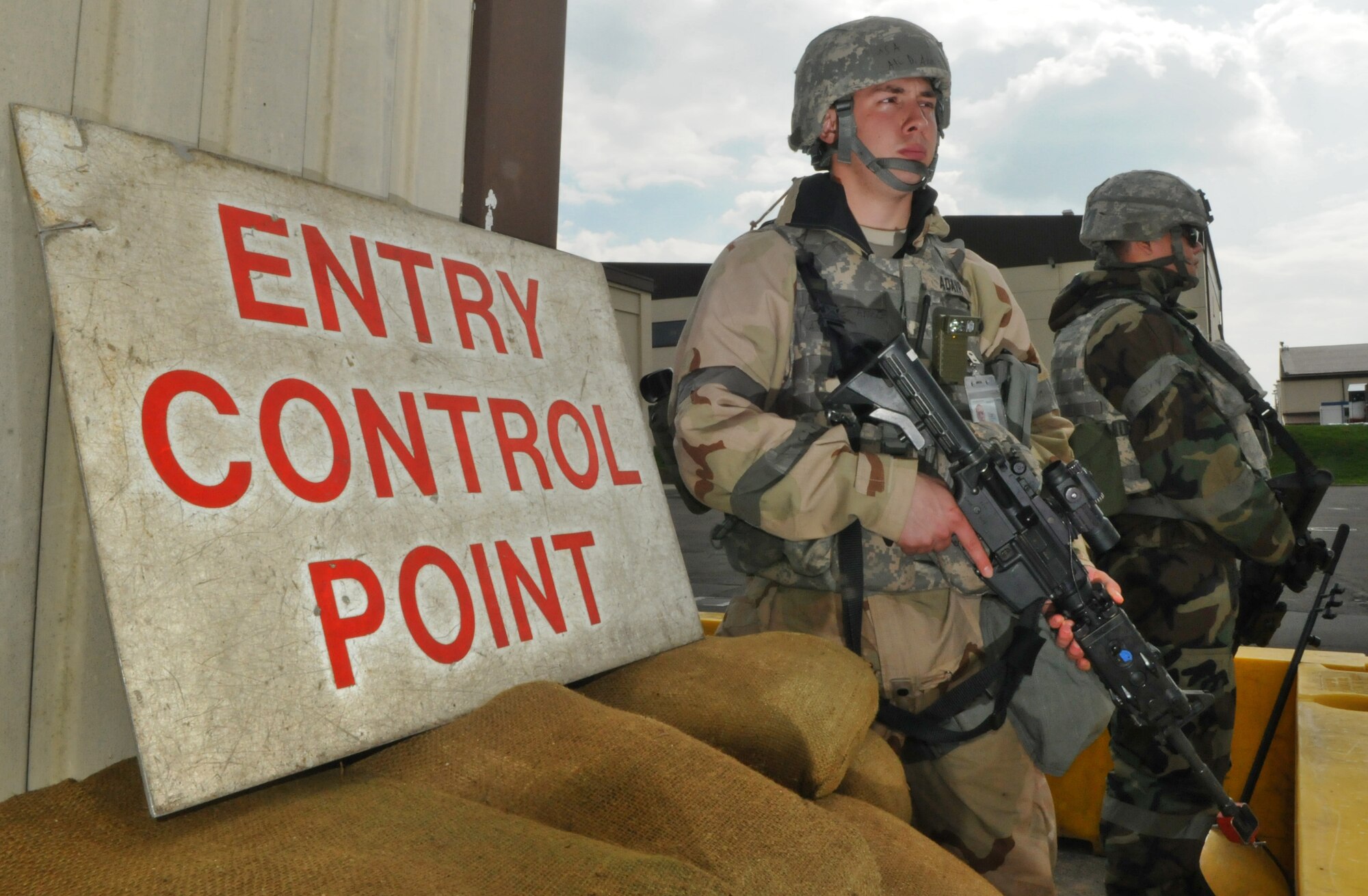 SPANGDAHLEM AIR BASE, Germany – Airman 1st Class Daniel Adair, 52nd Security Forces Squadron police officer, left, and Senior Airman Lenjie Olbrantz, 52nd SFS police officer, guard the entry control point to the simulated area of responsibility during Operation Saber Crown 10-6 April 27. Members of the 52nd Fighter Wing participated in the Phase II exercise to evaluate the wing’s ability to survive and operate in a chemical, biological, radiological, nuclear and explosive environment. (U.S. Air Force photo/Airman 1st Class Nick Wilson)