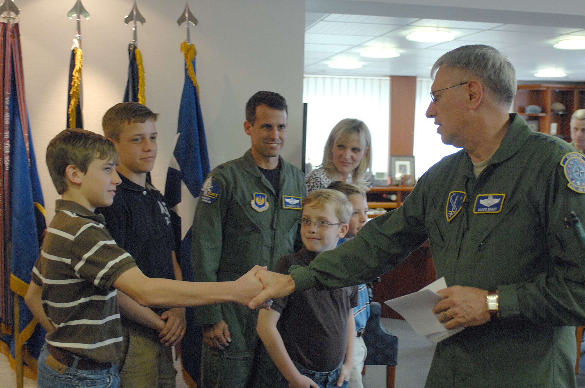 Gen. Roger Brady shakes hands with Hunter Koltes, 13, before announcing Hunter won the Year of the Air Force Family video competition, April 21, 2010, at Ramstein Air Force Base, Germany. General Brady congratulated Hunter and presented him a commander's coin for his tribute video called, "Life of a Military Brat." Hunter will also receive a computer and a video camera for winning the competition. General Brady is the U.S. Air Forces in Europe commander. (U.S. Air Force photo/Master Sgt. Corey Clements)
