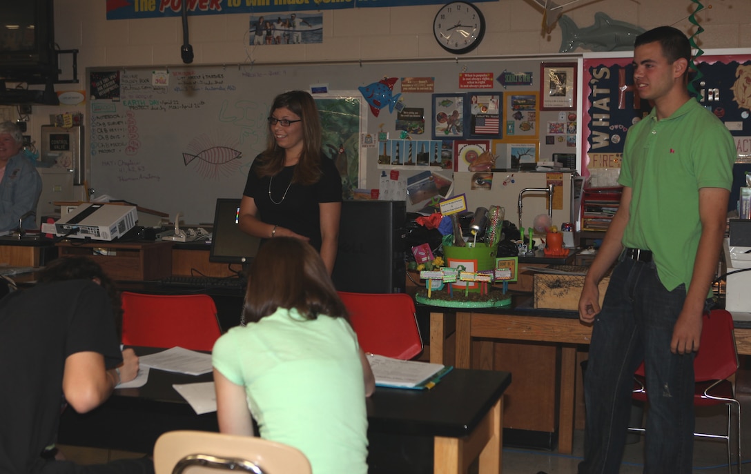 Hailee-Ann Hussey (left) and Jason Hall Jr. (right), students at Lejeune High school aboard Marine Corps Base Camp Lejeune, present their recycling science project to their biology class, April 30.  Hussey and Hall researched the effects of recycling on the Earth and placed recycling bins throughout parts of Onslow Beach and Camp Lejeune barracks so they could collect recyclables and improve the flowerbeds in front of Lejeune High School.