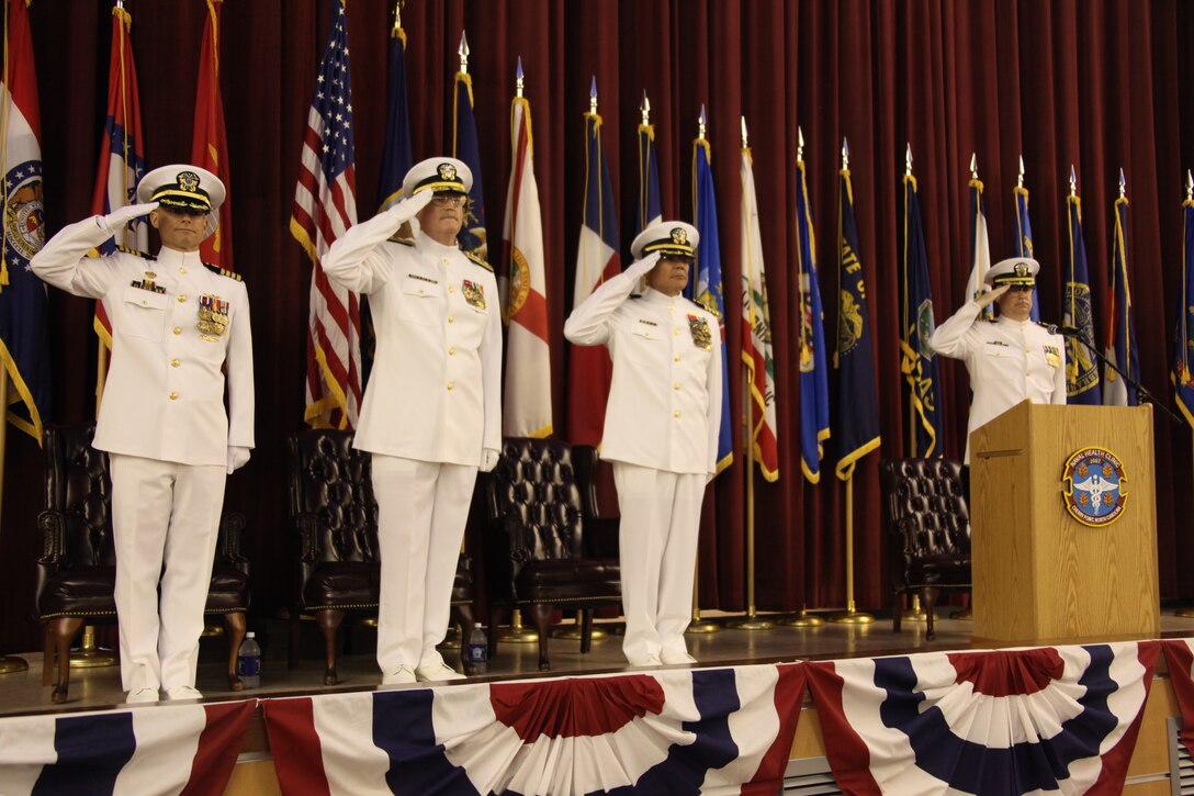 Navy Capt. John B. Burgess Jr., former commanding officer of Cherry Point’s Naval Health Clinic; Rear Adm. William R. Kiser, Navy Medicine East commander; Capt. Edgardo Perez-Lugo, the new Naval Health Clinic commanding officer; and Capt. William J. Leonard, the master of ceremonies for the change of command, stand and salute while the National Anthem is played at the Naval Health Clinic’s change of command ceremony, April 30.