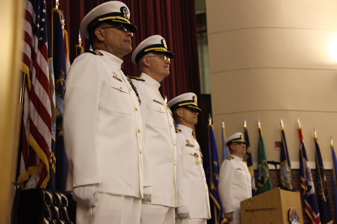 Navy Capt. Edgardo Perez-Lugo, the new Naval Health Clinic commanding officer, Navy Rear Adm. William R. Kiser, Navy medicine east commander, Navy Capt. John B. Burgess Jr., former commanding officer of Cherry Point’s Naval Health Clinic, stand at attention while the 2nd Marine Division Band plays “Anchors Aweigh” and “The Marines’ Hymn” at the Naval Health Clinic’s change of command ceremony, April 30.
