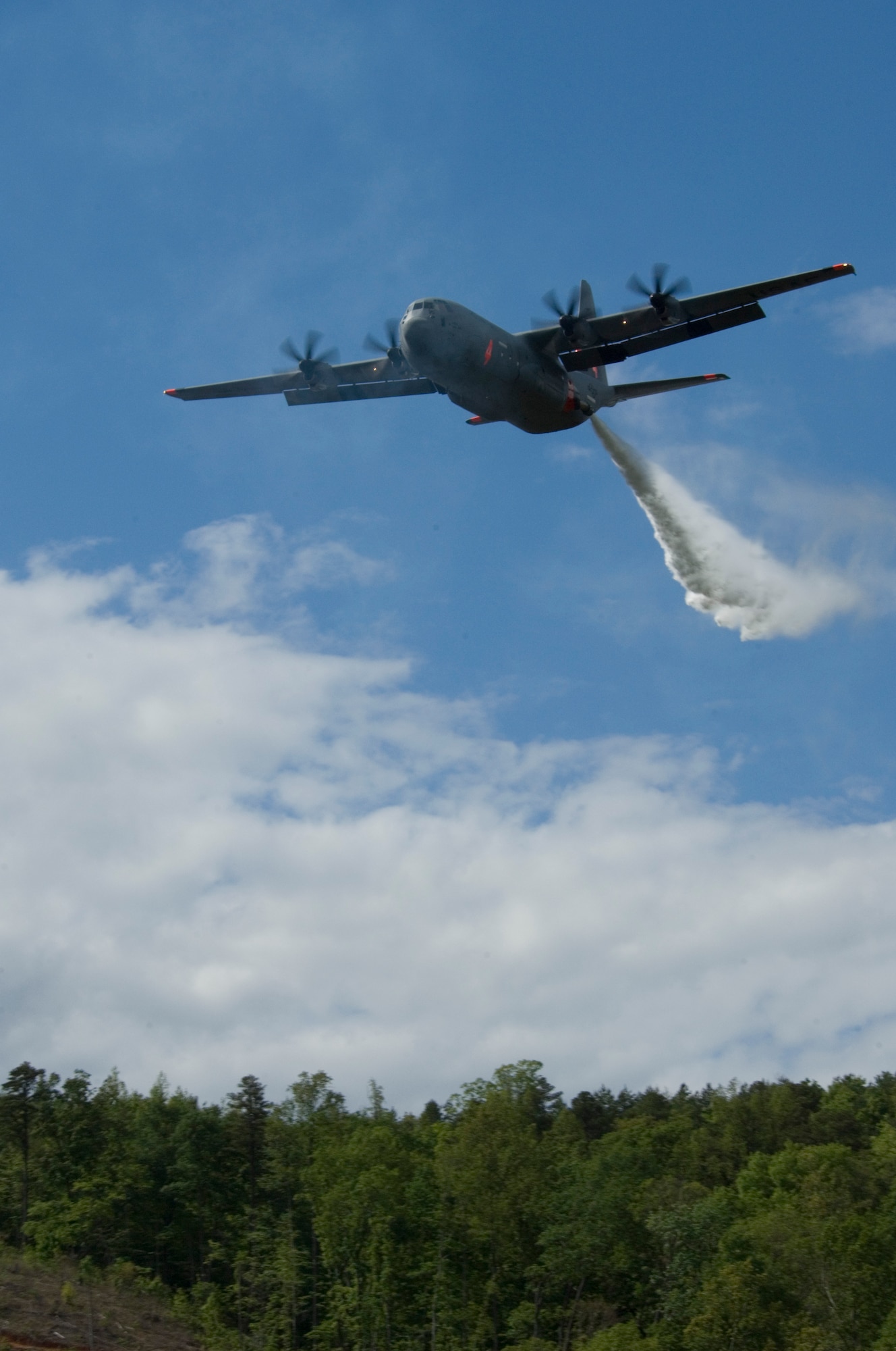 A C-130 from the 146th Airlift Wing located in Port Hueneme, Calif. drops water over the treetops in South Carolina. Modular Airborne Fire Fighting System, known as MAFFS, commenced annual training and certification this week in Greenville, S.C. April 26 to April 30, 2010. Photo by Airman 1st Class Nicholas Carzis
