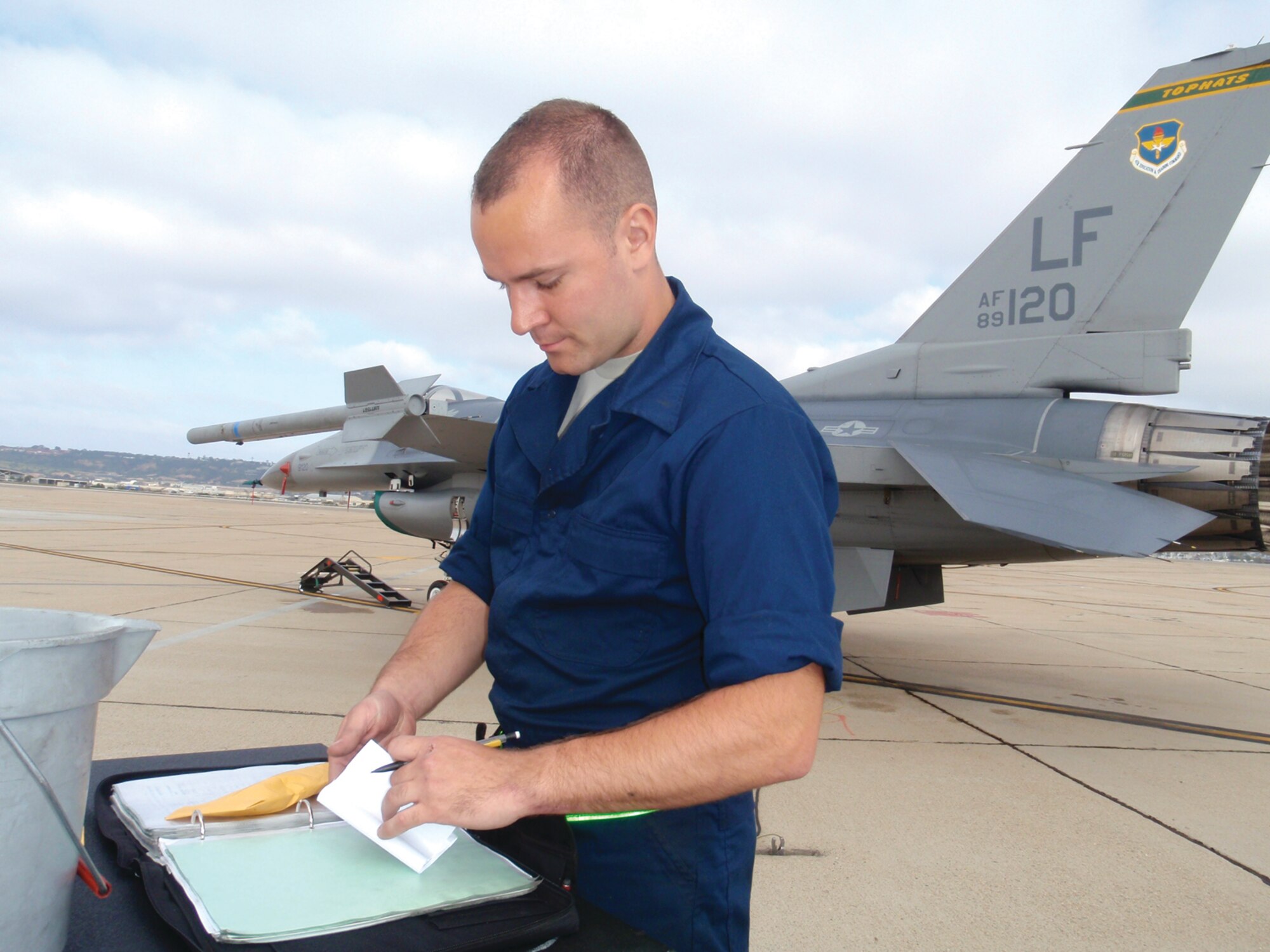 Airman 1st Class Jacob Peck, 310th Aircraft Maintenance Unit, completes paperwork while preparing a 310th Fighter Squadron F-16 for flight during the April 9 through 19 deployment to Naval Air Station North Island, Calif.