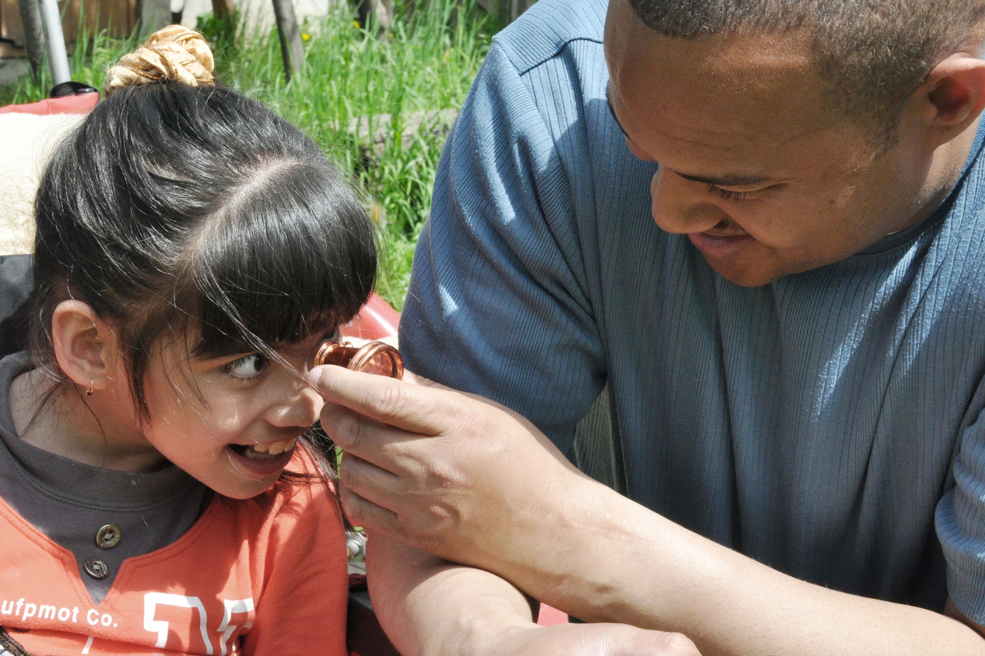 Master Sgt. Anthony Blalock helps a girl look through a kaleidoscope April 27, 2010, at the Nadjeshda Children's Center in Kyrgyzstan. Nadjeshda is home for 60 children and teenagers who are disabled in different ways. Sergeant Blalock is assigned to the Transit Center at Manas. (U.S. Air Force photo/Staff Sgt. Carolyn Viss)