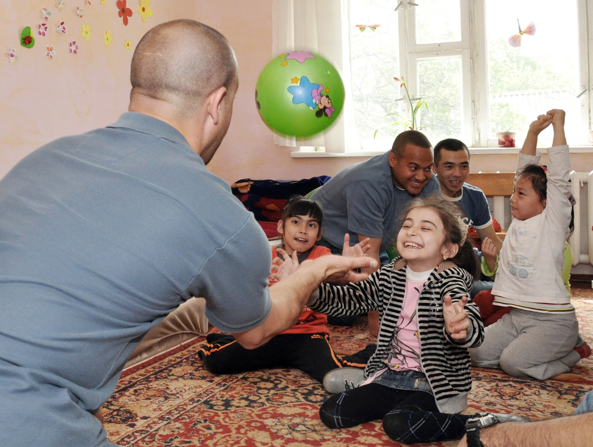 Master Sgt. Jeff Villemarette plays with children April 27, 2010, at the Nadjeshda Children's Center in Kyrgyzstan. Nadjeshda is home for 60 children and teenagers who are disabled in different ways. Sergeant Villemarette is assigned to the Transit Center at Manas. (U.S. Air Force photo/Staff Sgt. Carolyn Viss)