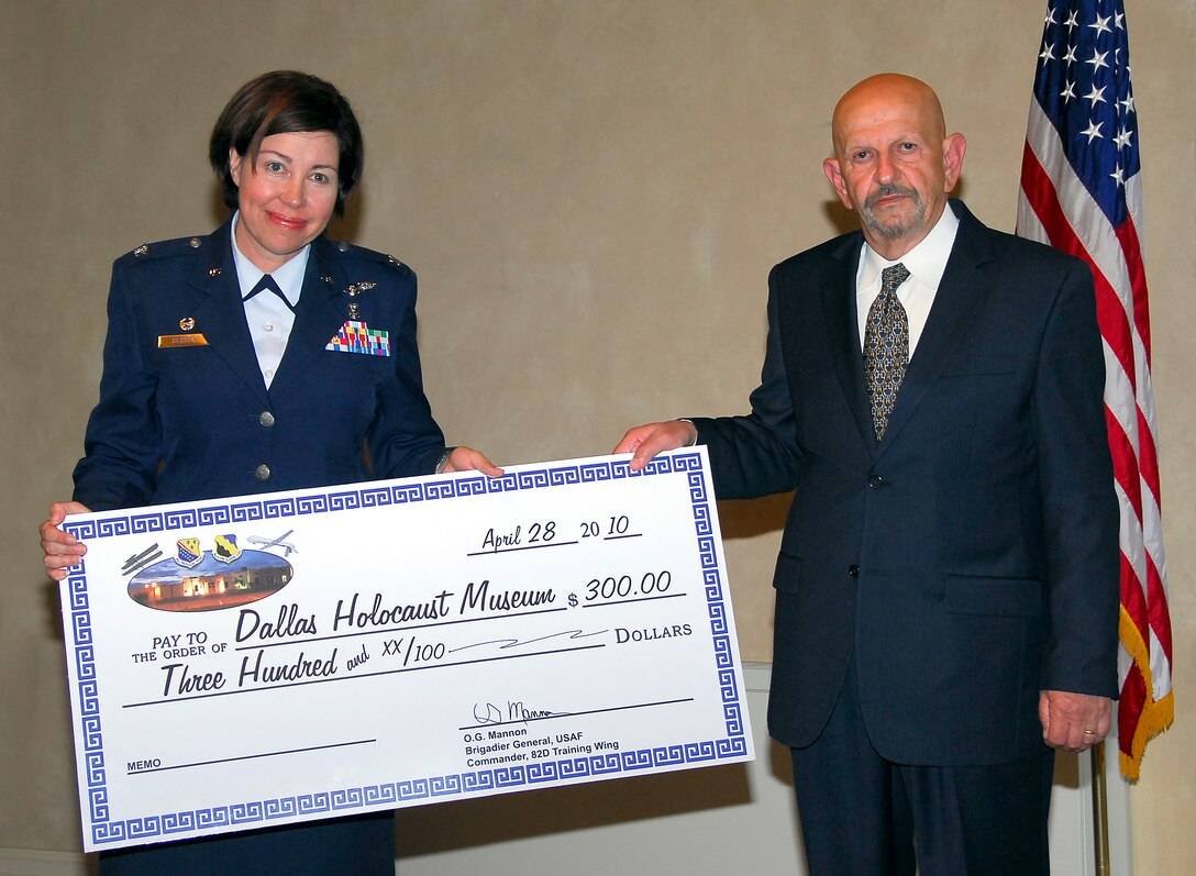 Team Sheppard donates $300 to the Dallas Holocaust Museum at the Holocaust Remembrance Service at the North Chapel April 29, 2010. Col. Lista Benson, 882nd Training Group commander, presented the donation check to Paul Kessler the guest speaker for the event. Mr. Kessler spoke about the significance of upstanders during the Holocaust. (U.S. Air Force Photo/Harry Tonemah)