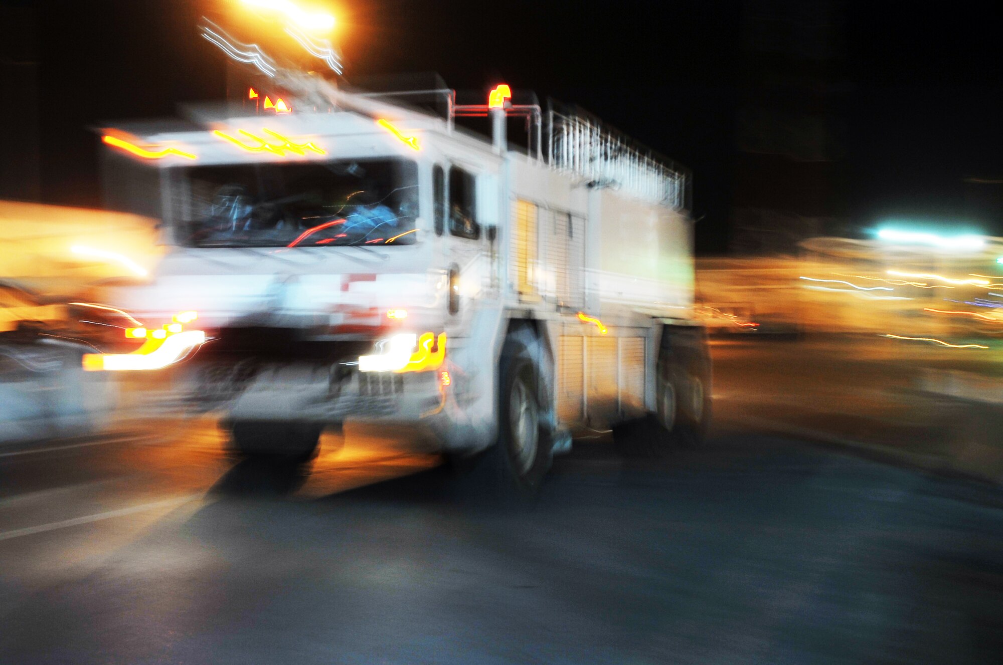 A crew of firefighters from the 380th Expeditionary Civil Engineer Squadron respond to an emergency in their truck during night operations April 30, 2010, at a non-disclosed base in Southwest Asia. The 380th ECES, as part of the 380th Air Expeditionary Wing, supports operations Iraqi Freedom and Enduring Freedom and the Combined Joint Task Force-Horn of Africa. (U.S. Air Force Photo/Master Sgt. Scott T. Sturkol/Released)