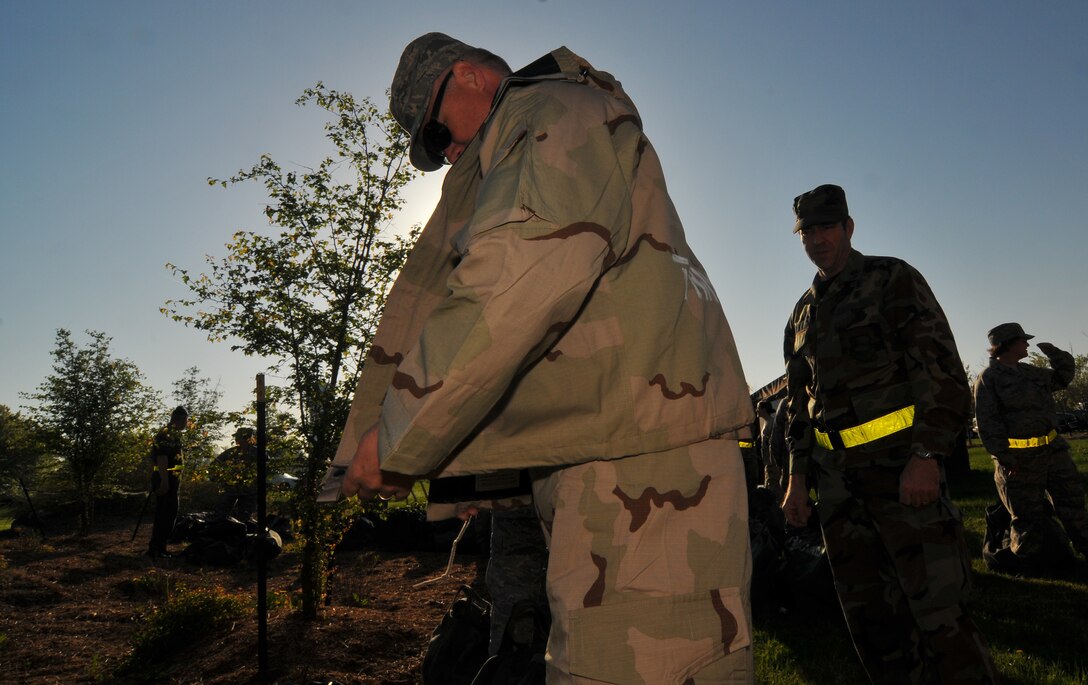 An Air Force Reservist puts on his chemical ensemble suit during a practice session.  932nd Airlift Wing members gathered for Ability to Survive and Operate training just prior to the April drill weekend.  They learned more about their weapons, Airman's manual and taking care of first aid for themselves and others.  (U.S. Air Force photo/Tech Sgt. Chris Parr)