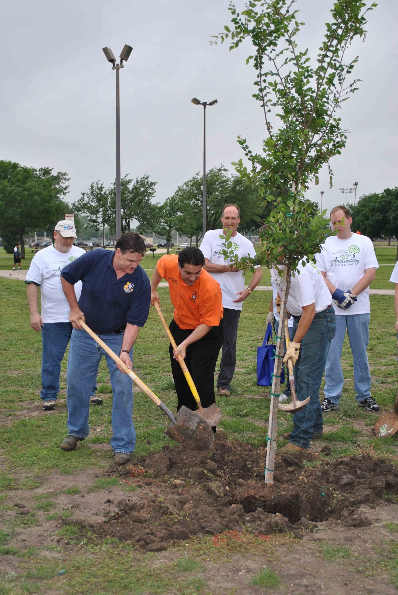 AFRPA Director Robert Moore (L), joined by San Antonio City Councilman David Medina (C) plants a Spanish Oak tree in Kennedy Park. Deputy Director Jeff Domm is hidden by the tree. Colleagues wear t-shirts celebrating Earth Day's 40th anniversary. To see all photos from Trees Across America visit our website at <a class="changelink_normal" href="http://www.safie.hq.af.mil/afrpa">http://www.safie.hq.af.mil/afrpa</a>
